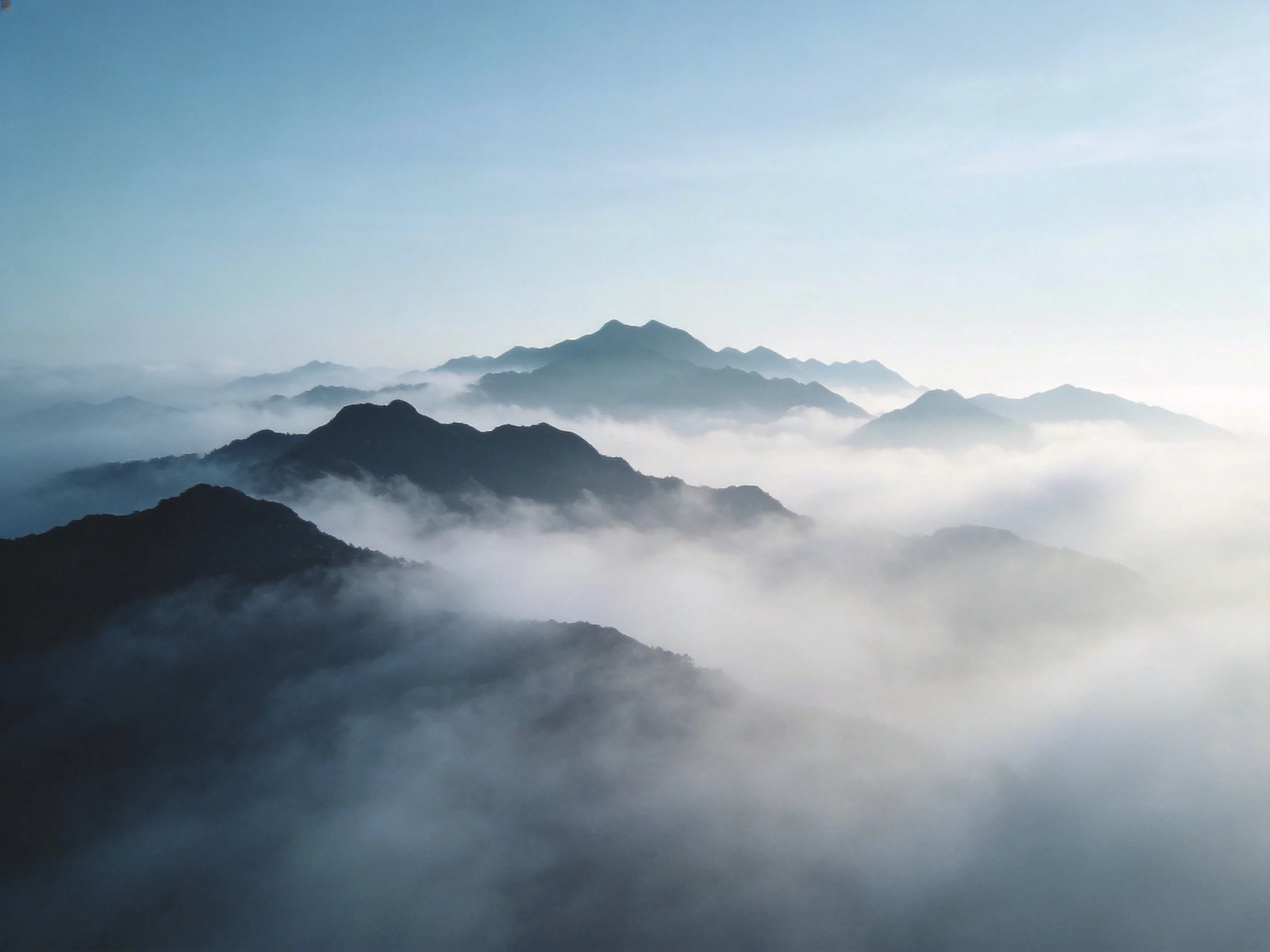 Misty mountain peaks layered in soft blue haze