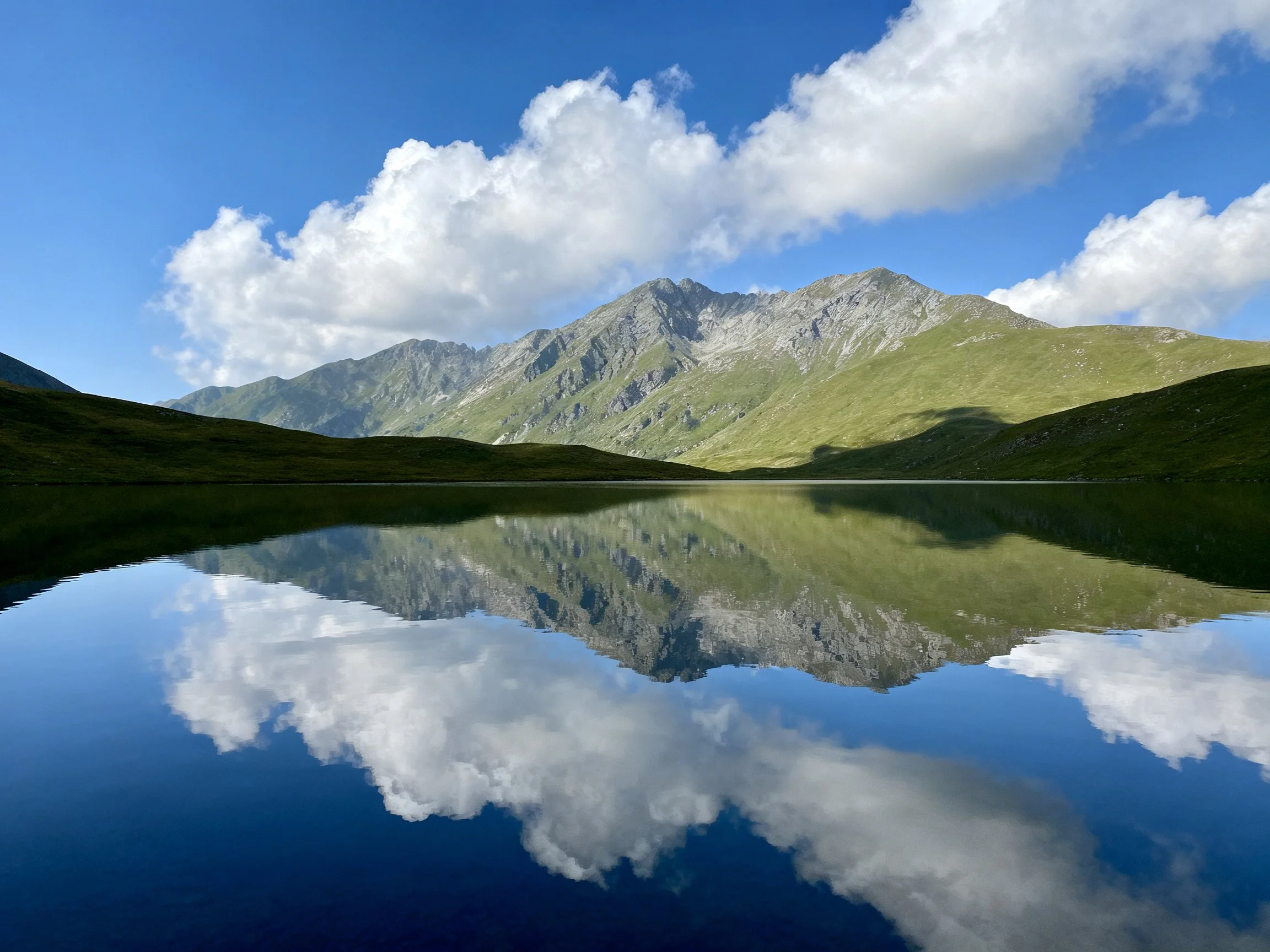 Mountain Peaks and Clouds Reflected in a Mirror-Like Lake