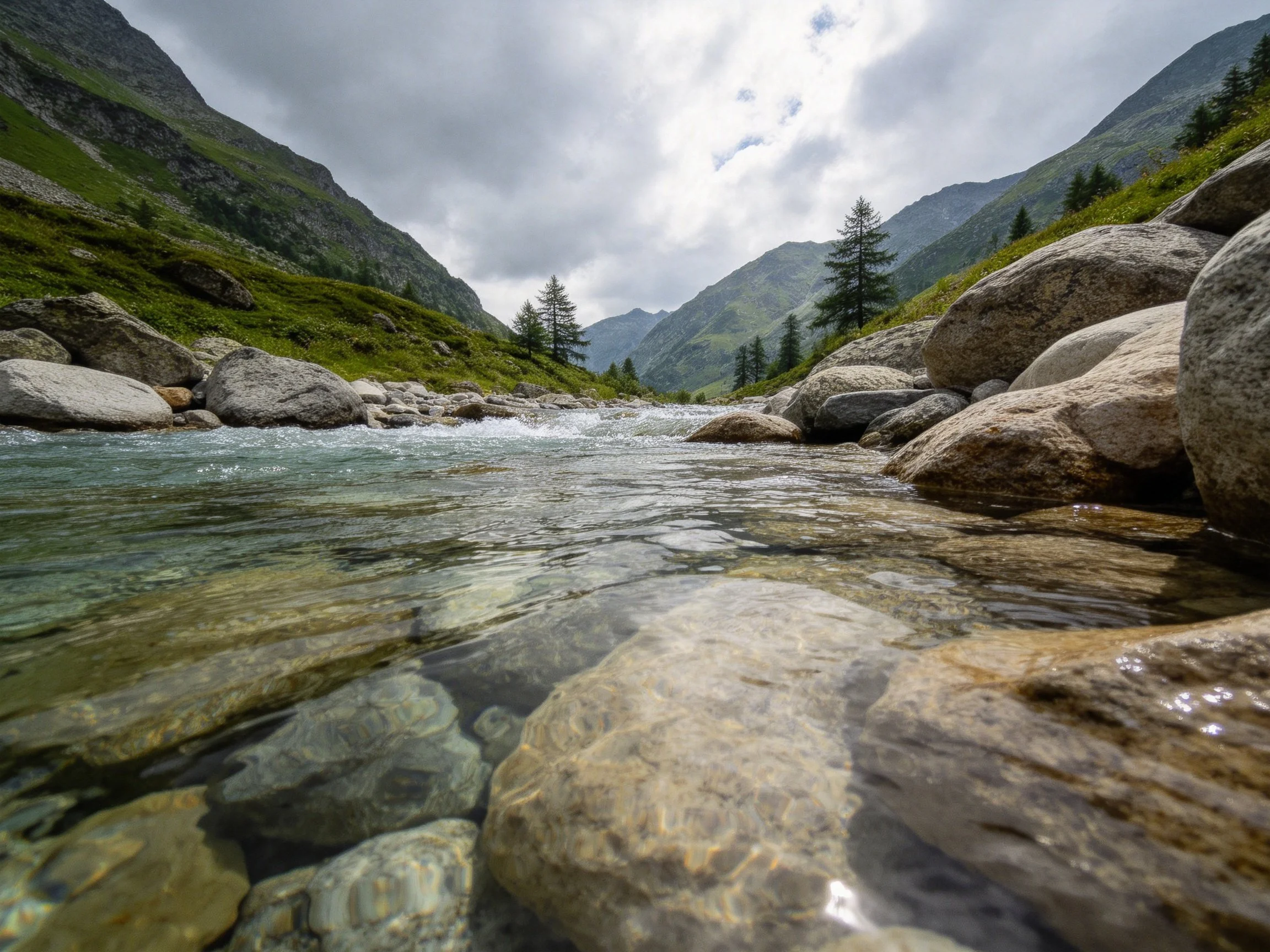 Mountain Stream Flows Over Large Rocks In Rocky Valley