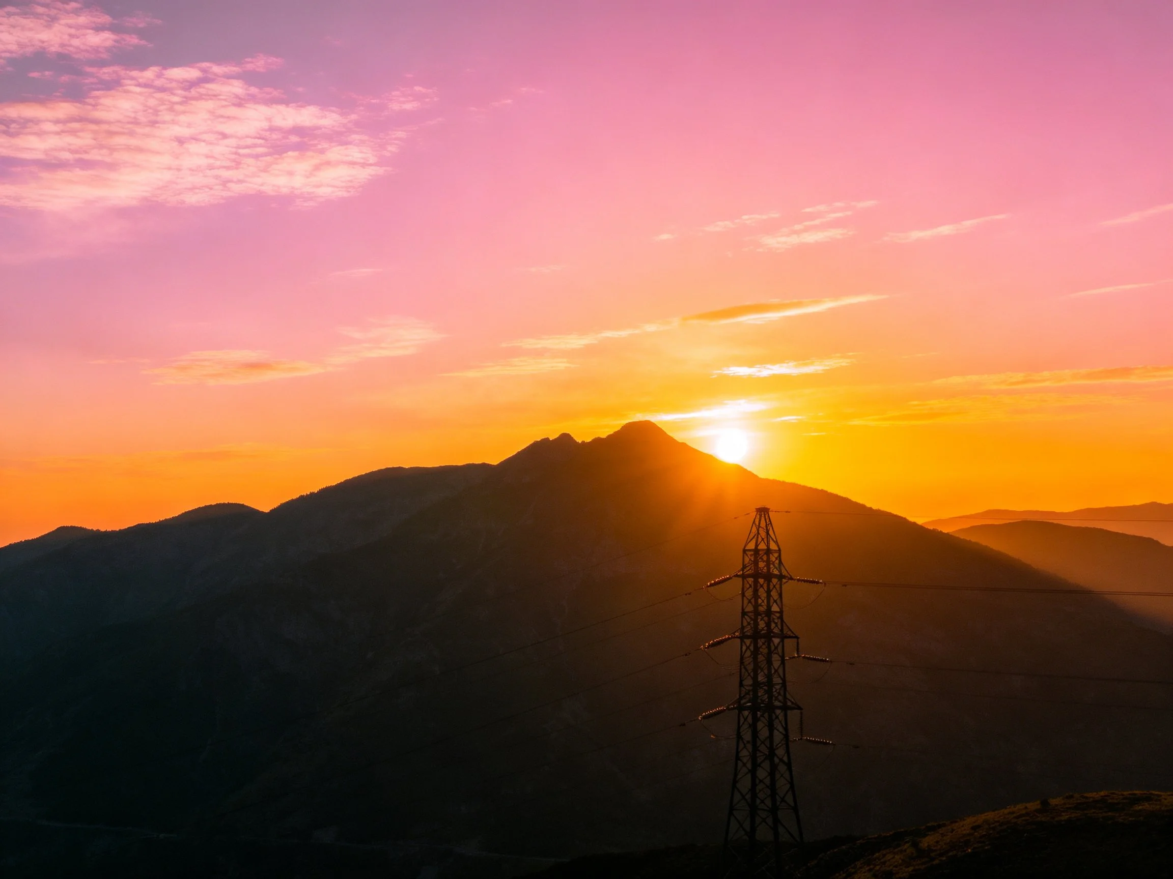 Mountain Sunset with Vibrant Sky and Power Tower