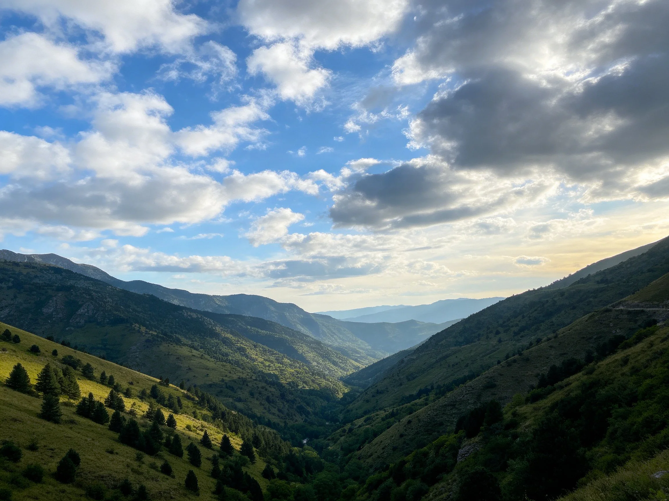 Mountain Valley with Lush Green Slopes and Cloudy Sky
