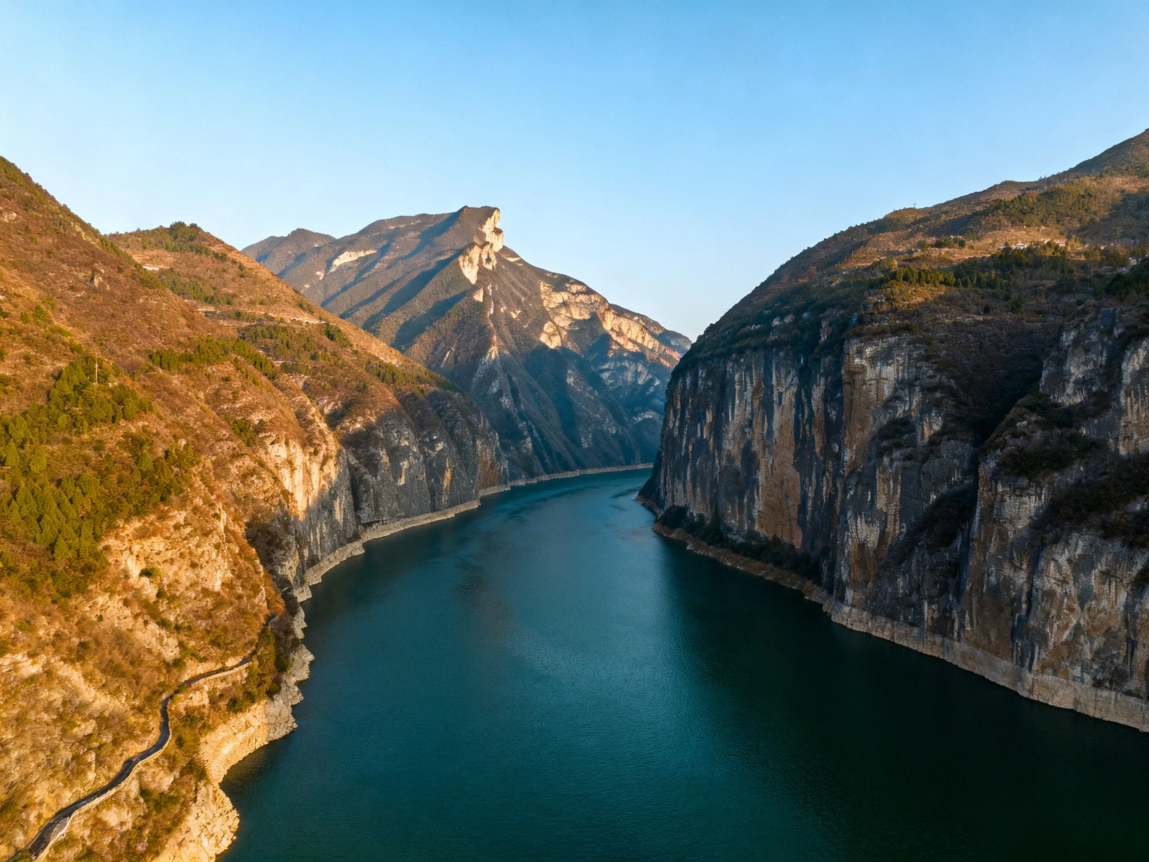 Narrow River Between Towering Cliffs and Mountain Peaks
