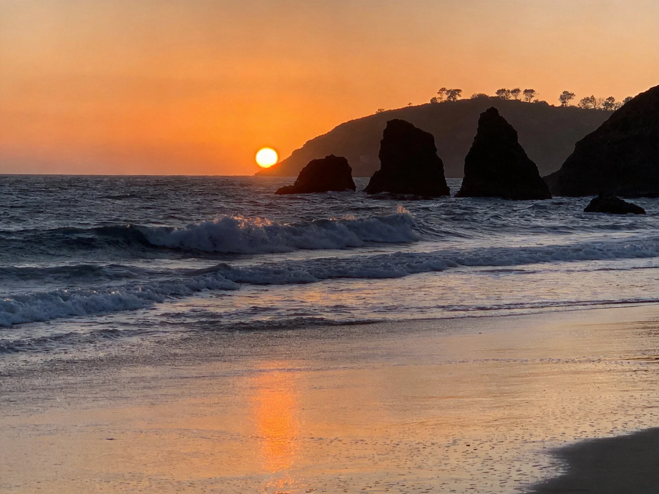 Orange Sunset at Rocky Coastal Shore with Waves
