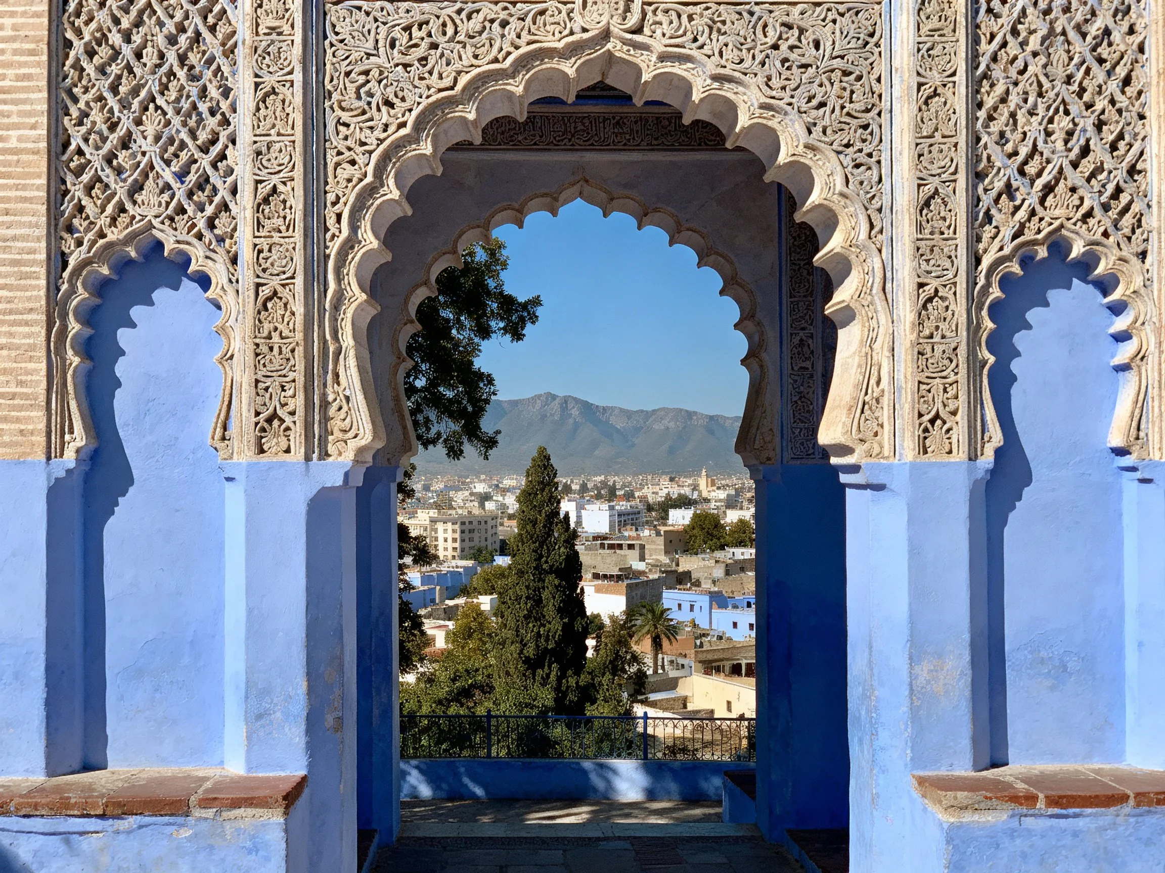 Ornate blue archway overlooking town and mountains