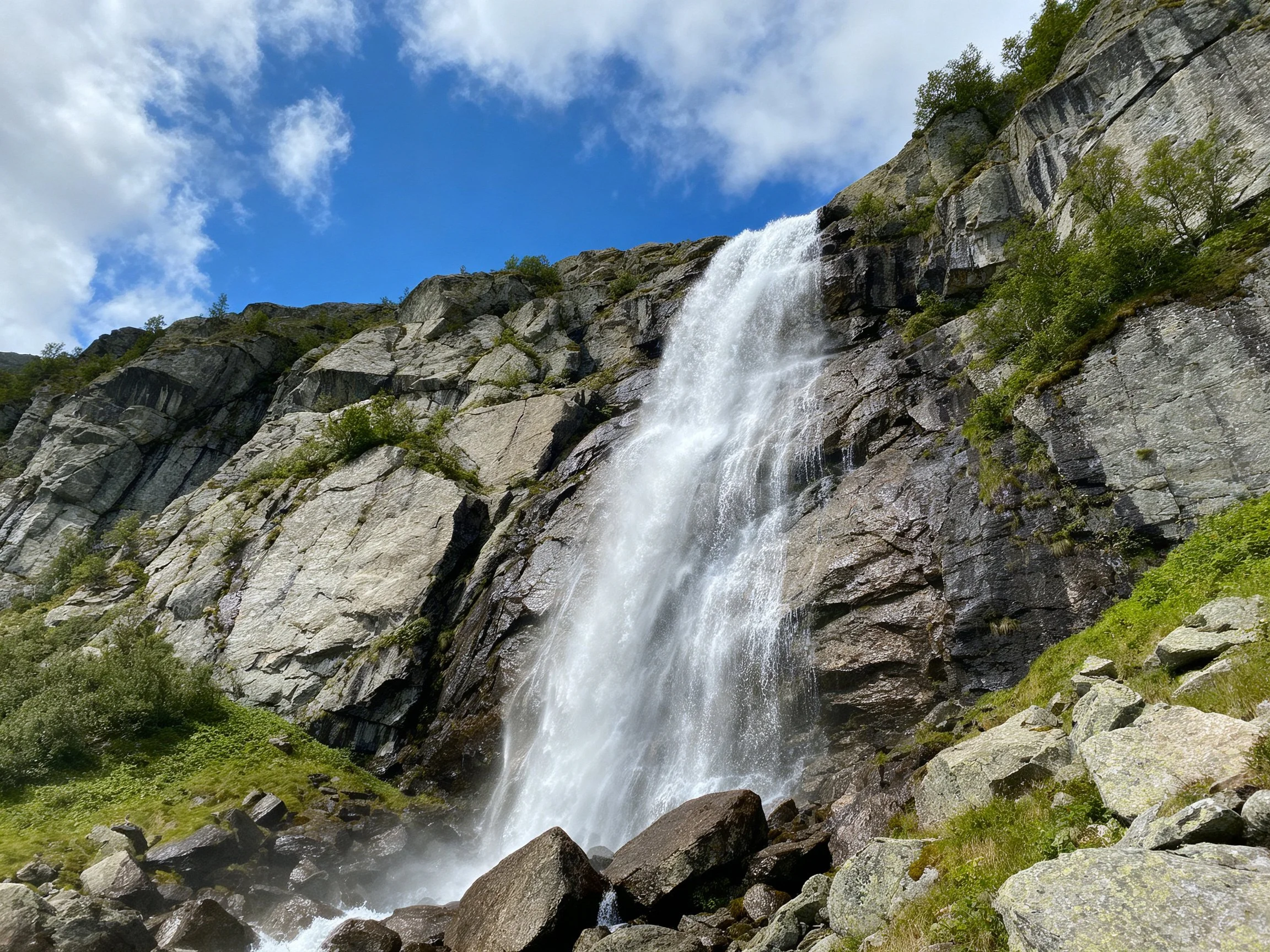 Powerful waterfall cascades down rugged gray rock cliffs