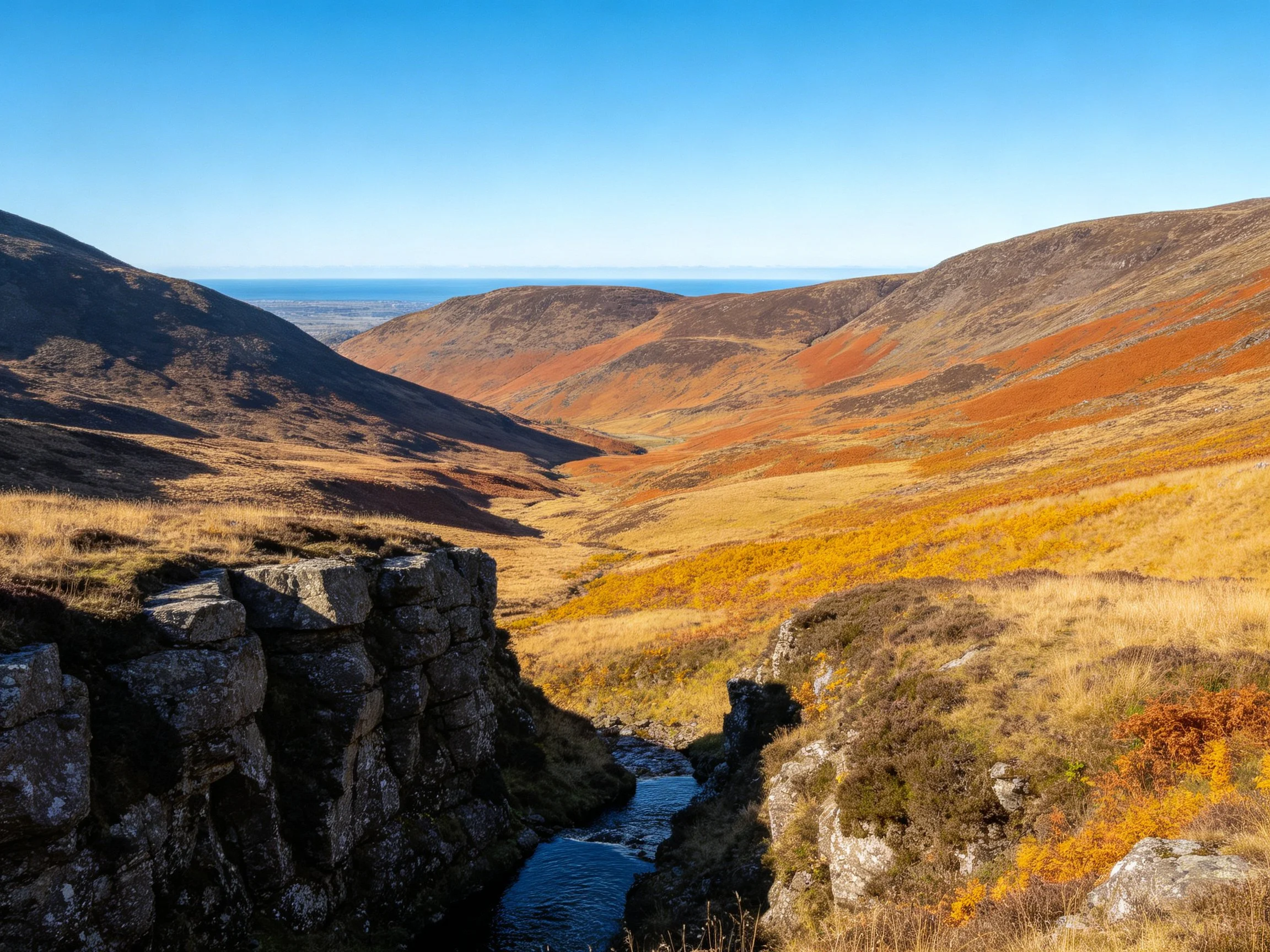 Rocky canyon with autumn-colored hills and a narrow stream