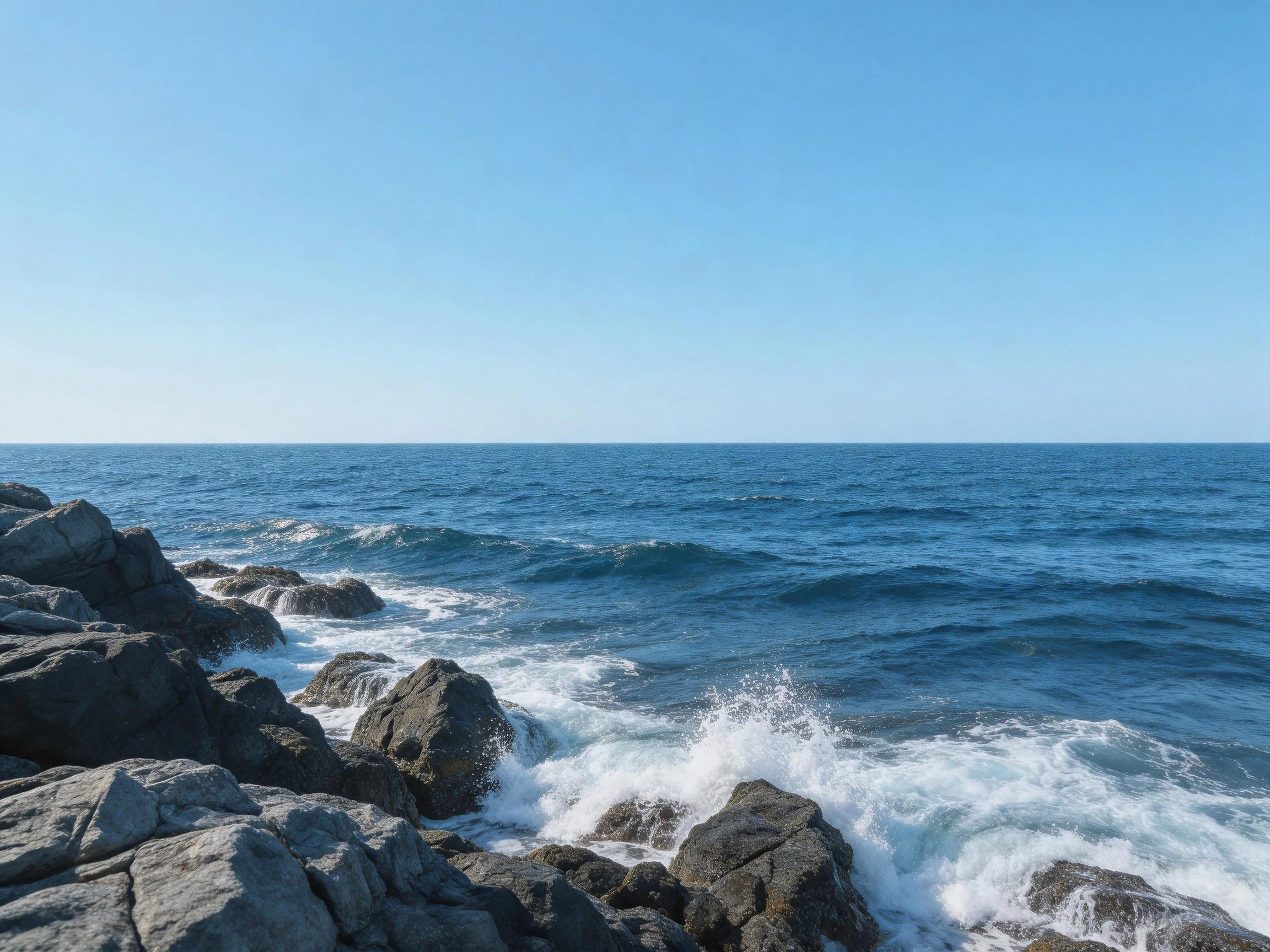 Rocky shoreline with crashing waves and deep blue sea
