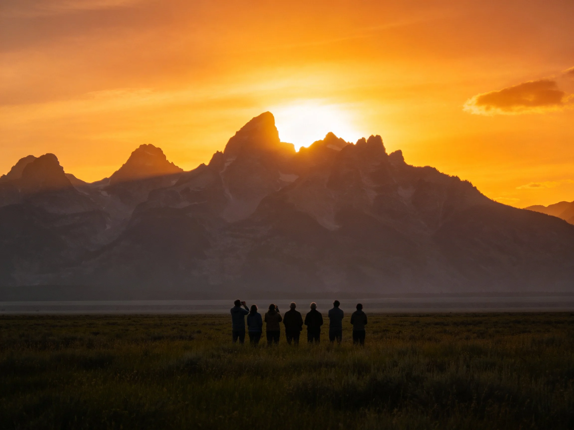 Silhouetted group near mountainpeaks at sunset