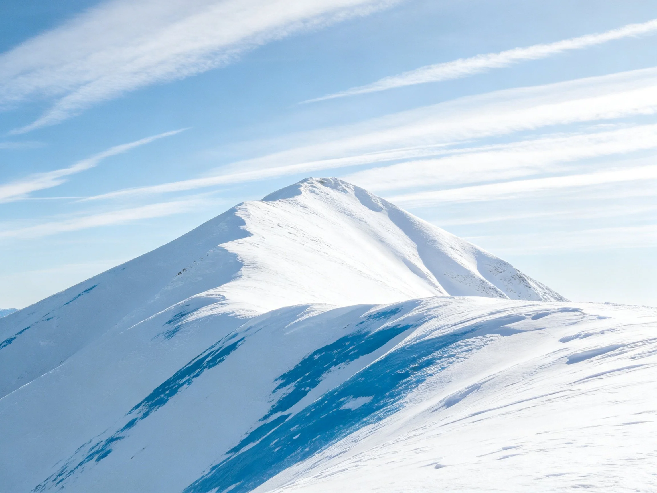 Snow-Capped Mountain Peak Under Bright Blue Sky