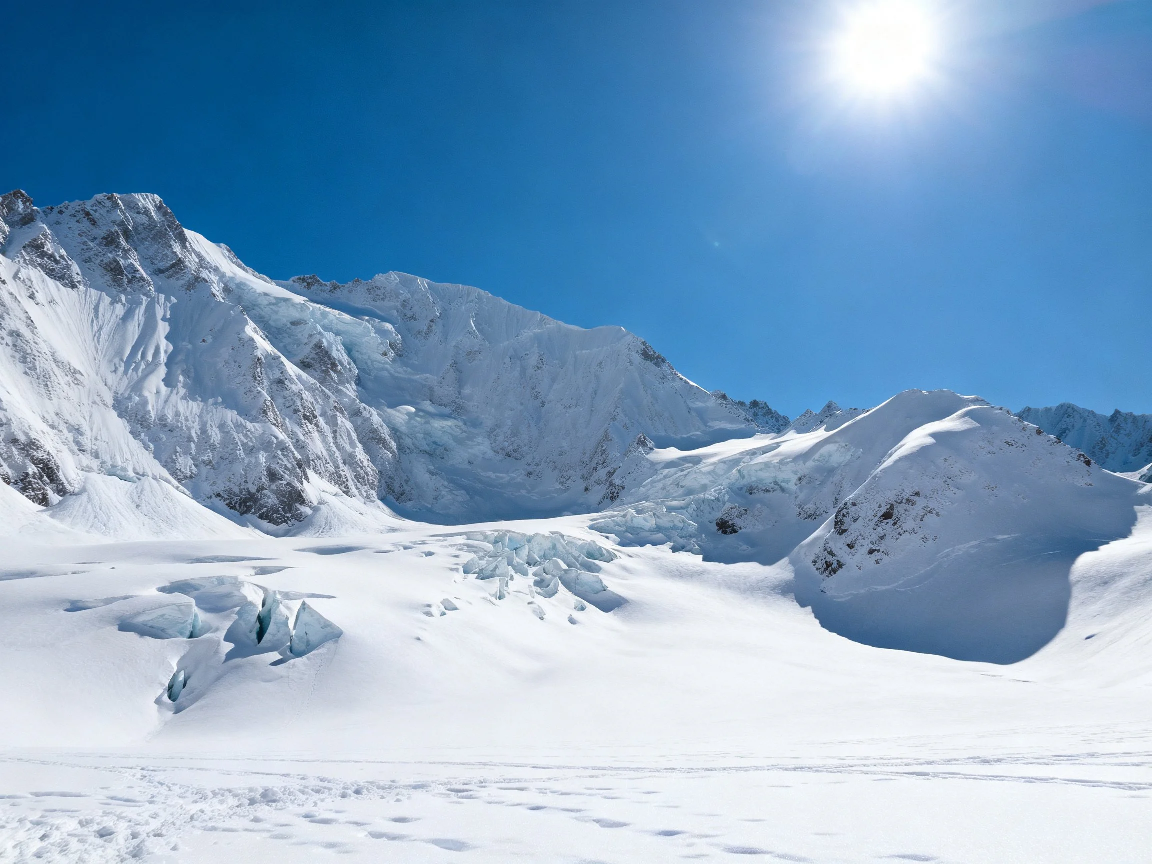 Snow-Capped Mountain Peaks With Glaciers and Clear Blue Sky