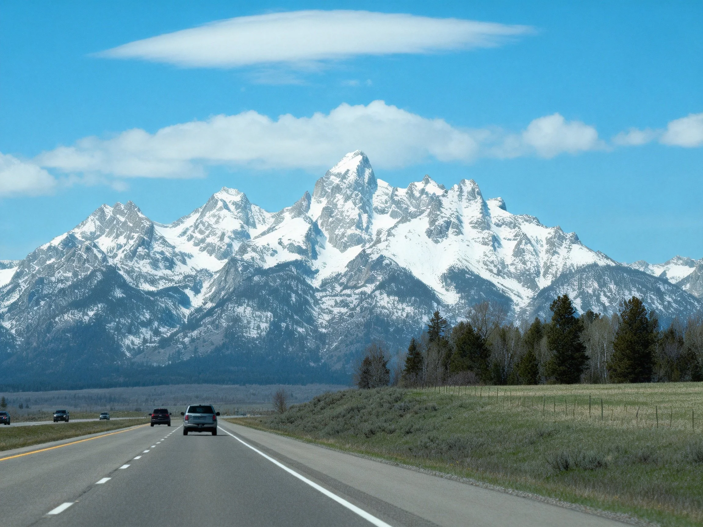 Snow-Capped Mountain Range Overlooking a Highway