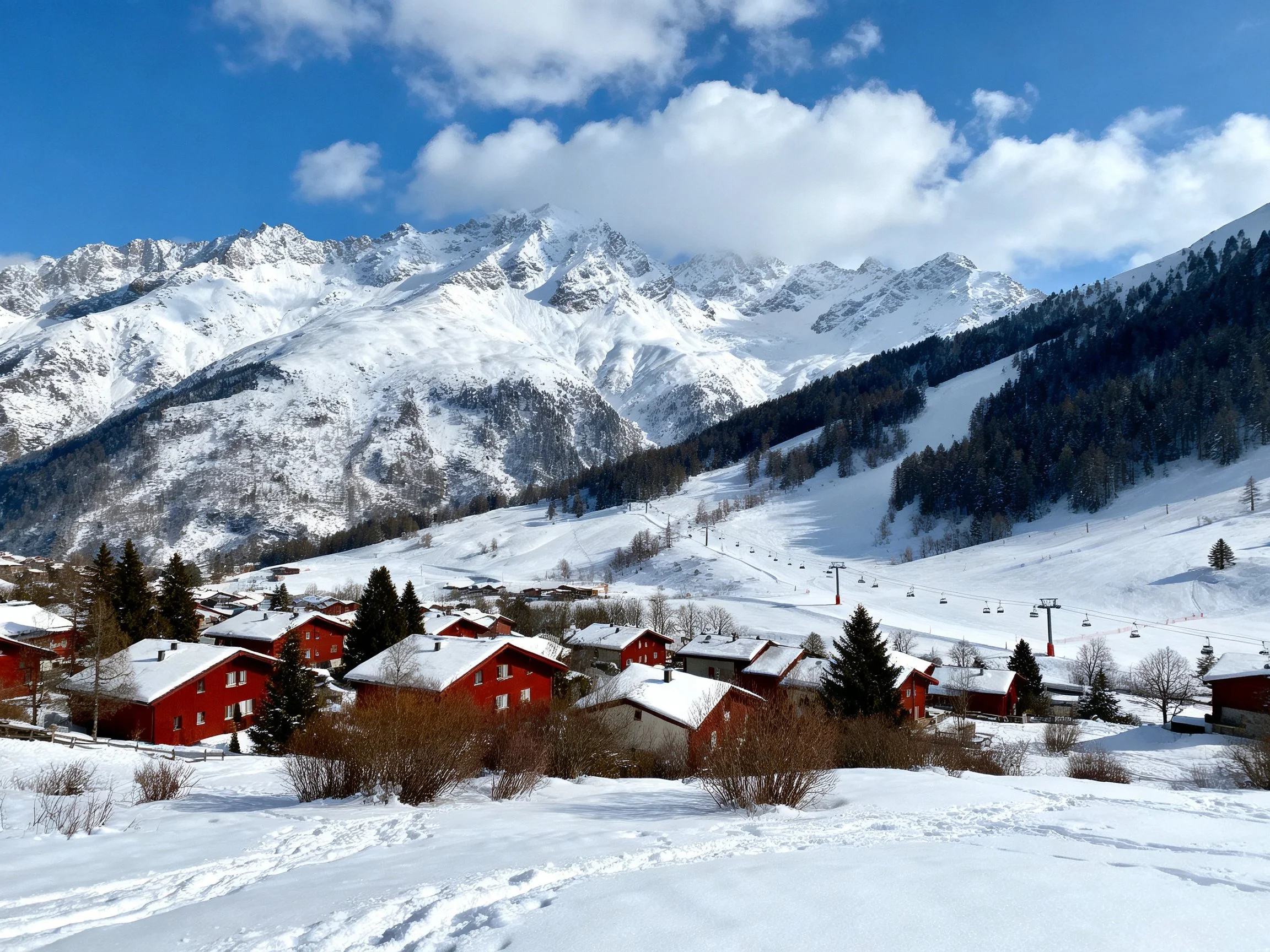 Snow-Capped Peaks Over Red Chalet Village Near Ski Slopes