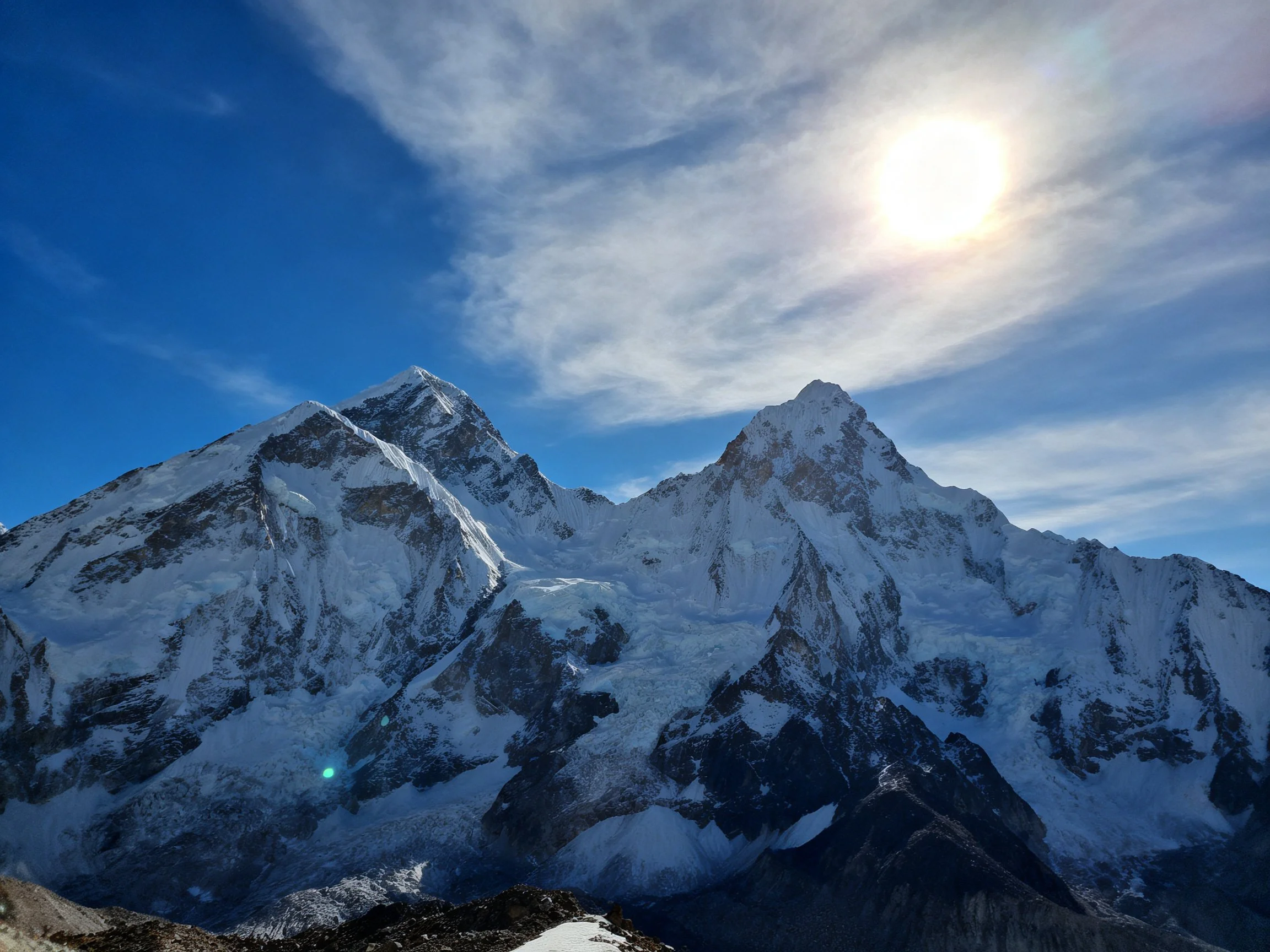 Snow-Capped Peaks Under Bright Sunlight With Blue Sky
