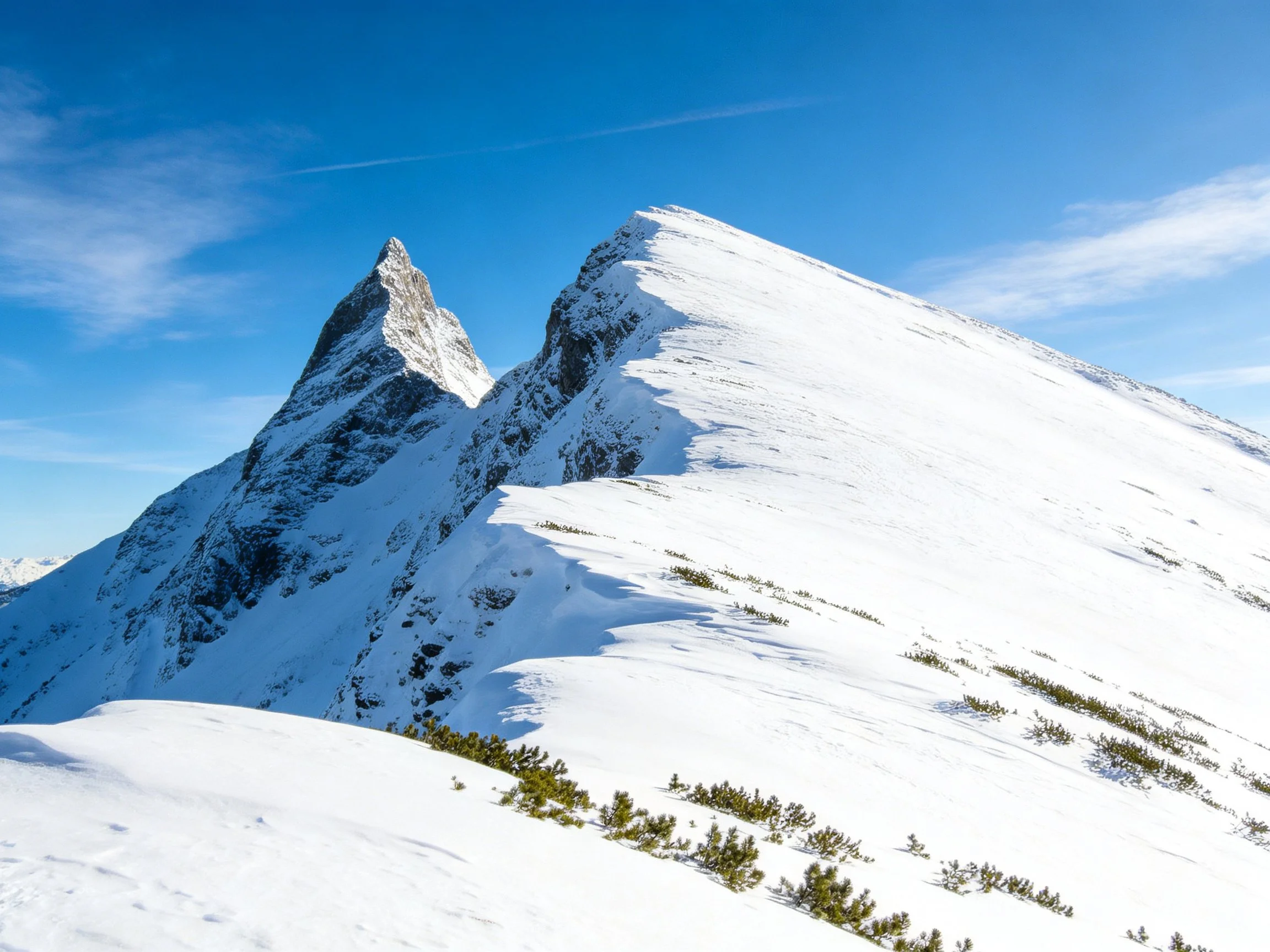 Snow-Capped Peaks with Rocky Summits and Clear Blue Skies