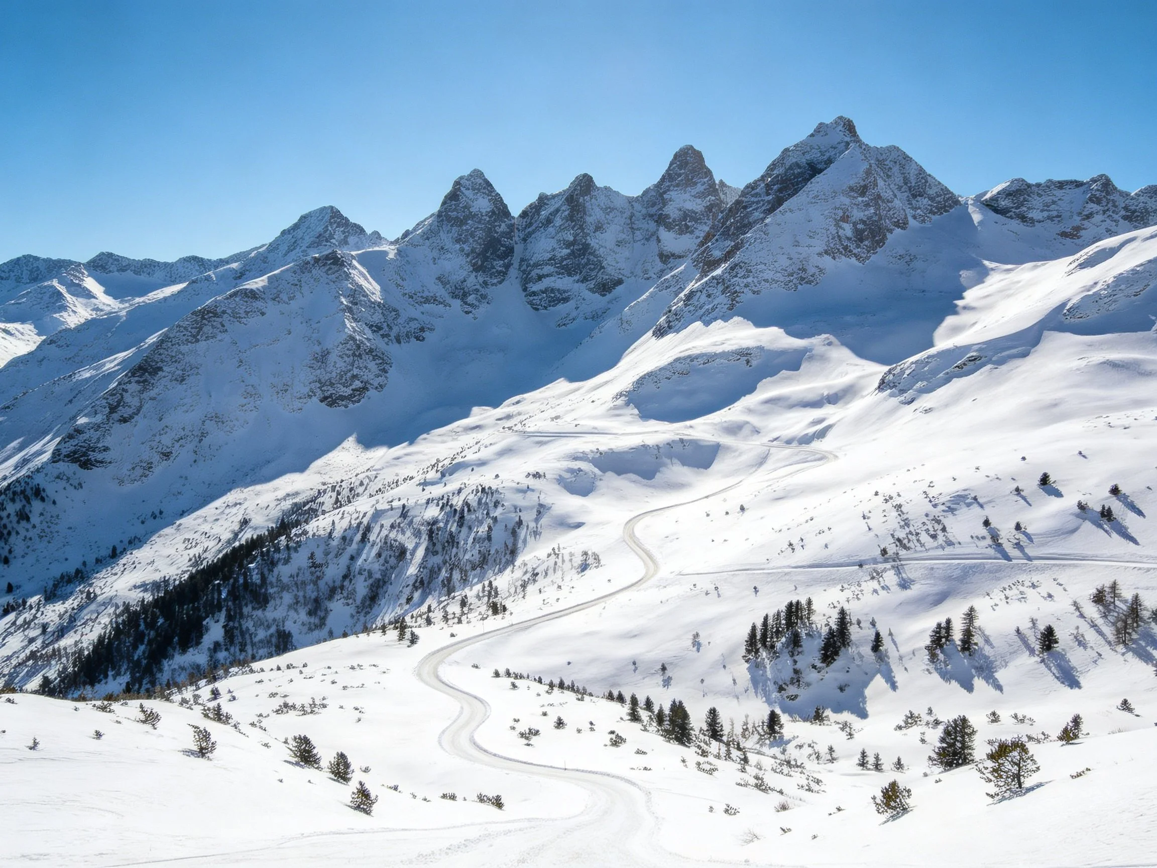 Snow-Covered Alpine Peaks with Winding Trails and Evergreen Clusters