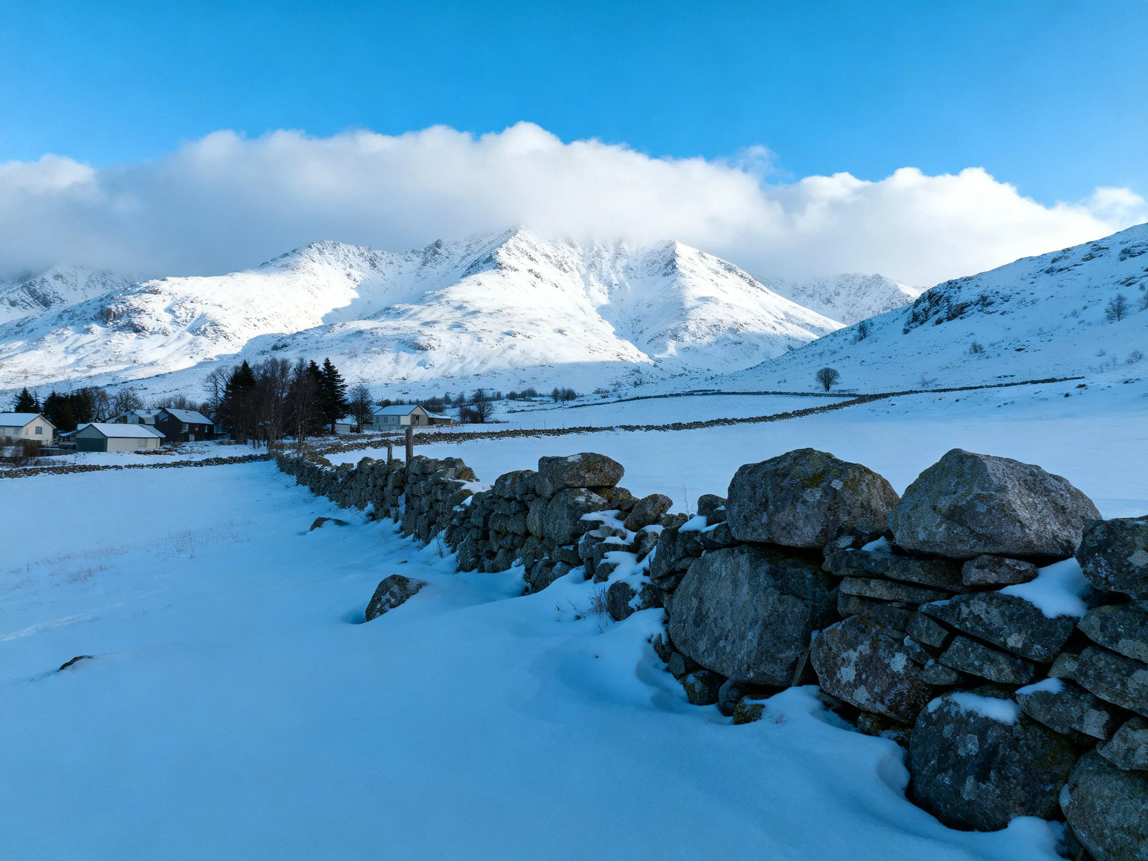 Snow-Covered Mountain Landscape with Stone Wall and Rural Buildings