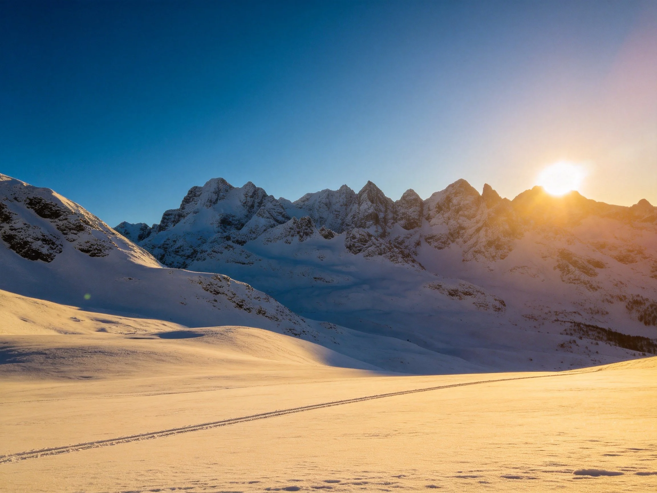 Snow-Covered Mountain Peaks Illuminated by Golden Sunset Light