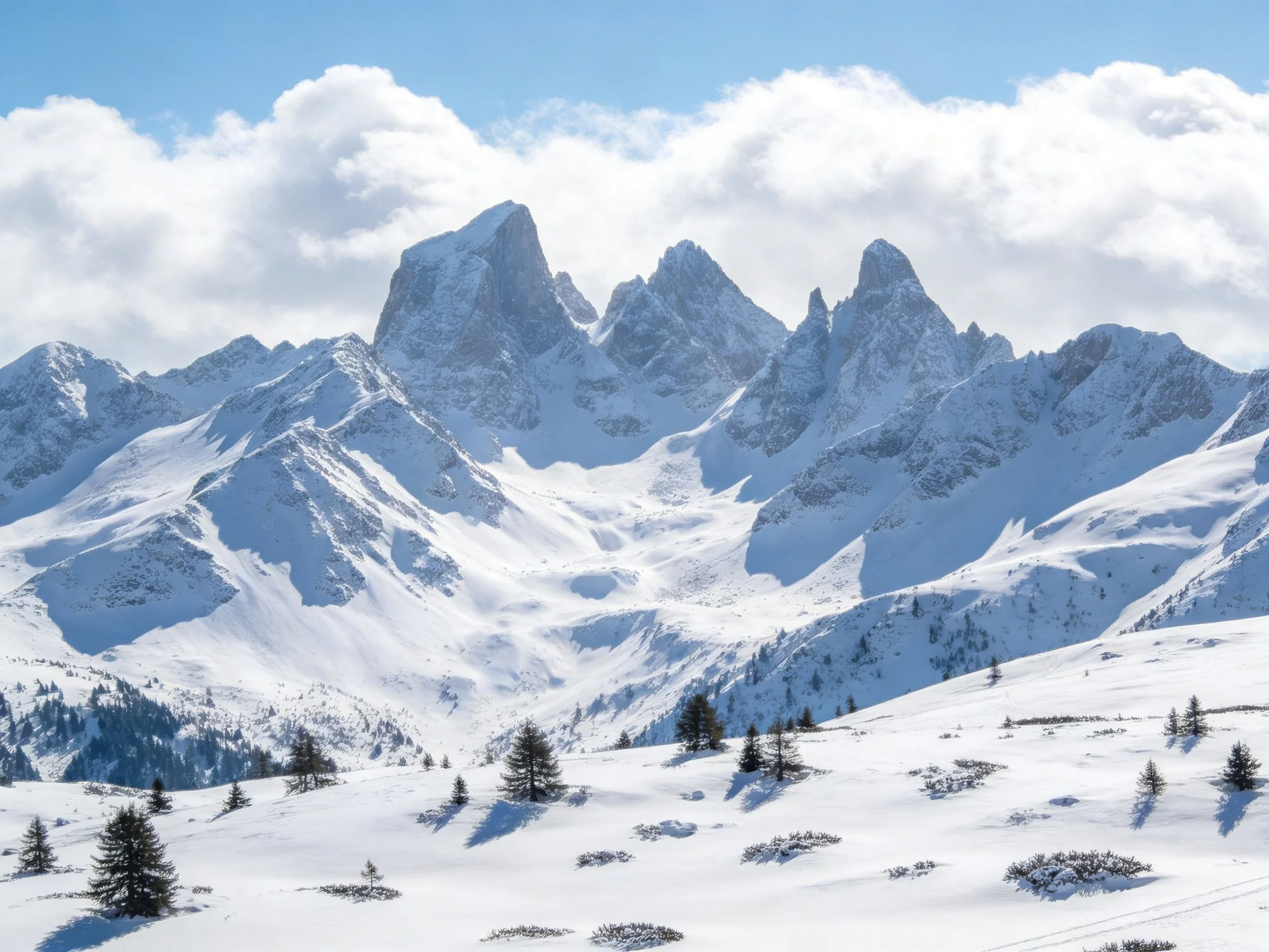 Snow-Covered Mountain Peaks With Sharp Summits Under Bright Sky