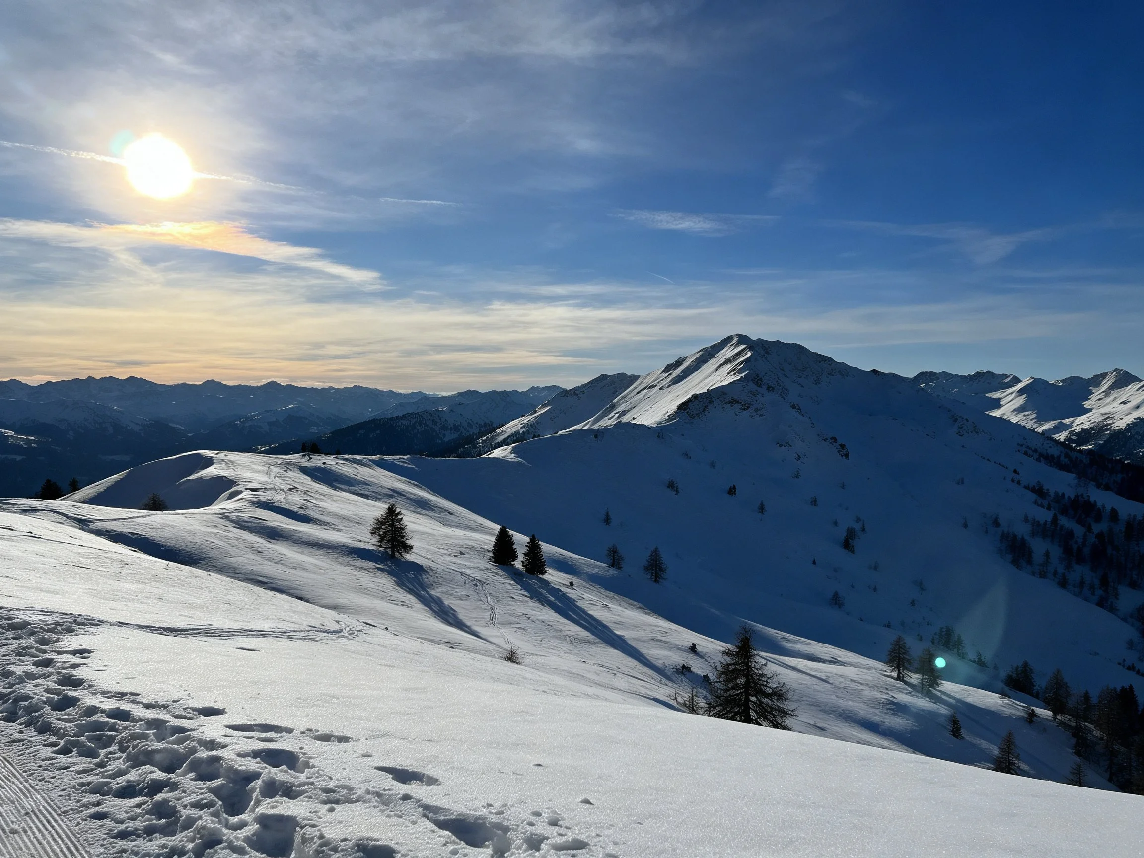 Snow-Covered Mountain Slopes with Bright Sun and Clear Blue Sky