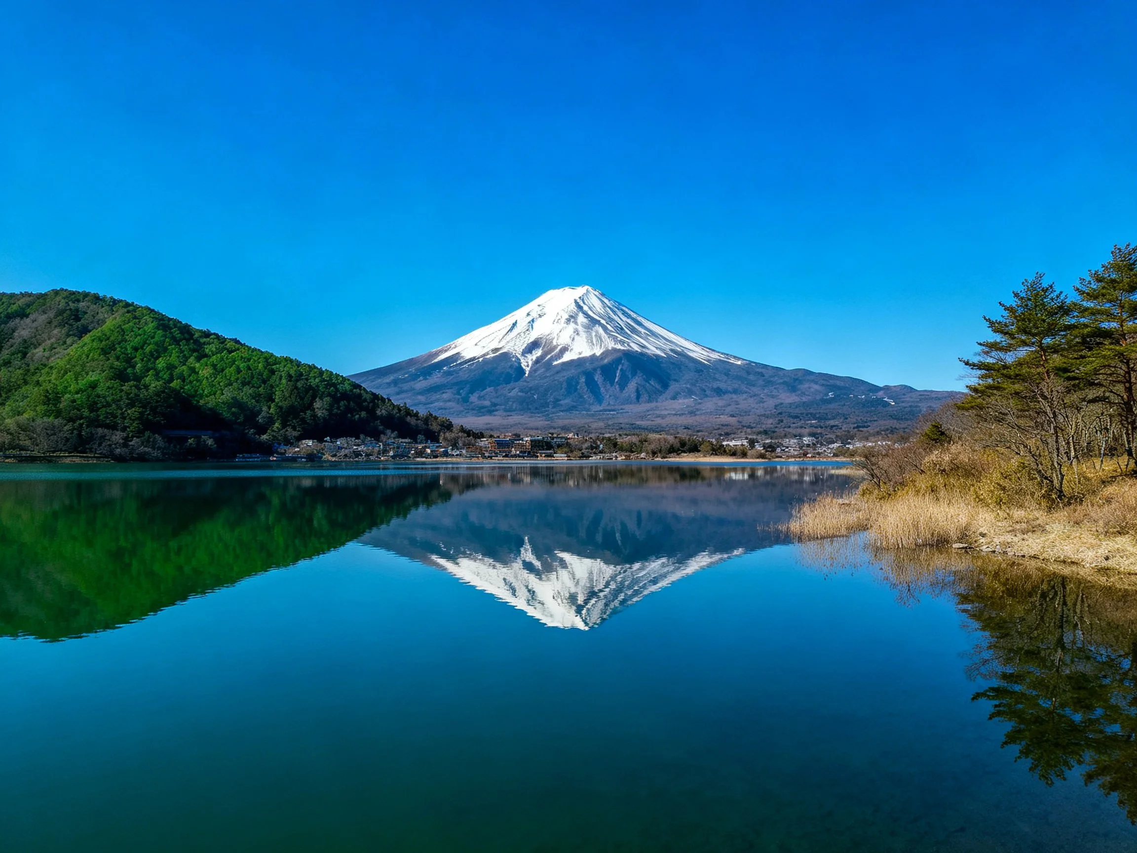 Snow - capped Mount Fuji reflected in a serene blue lake
