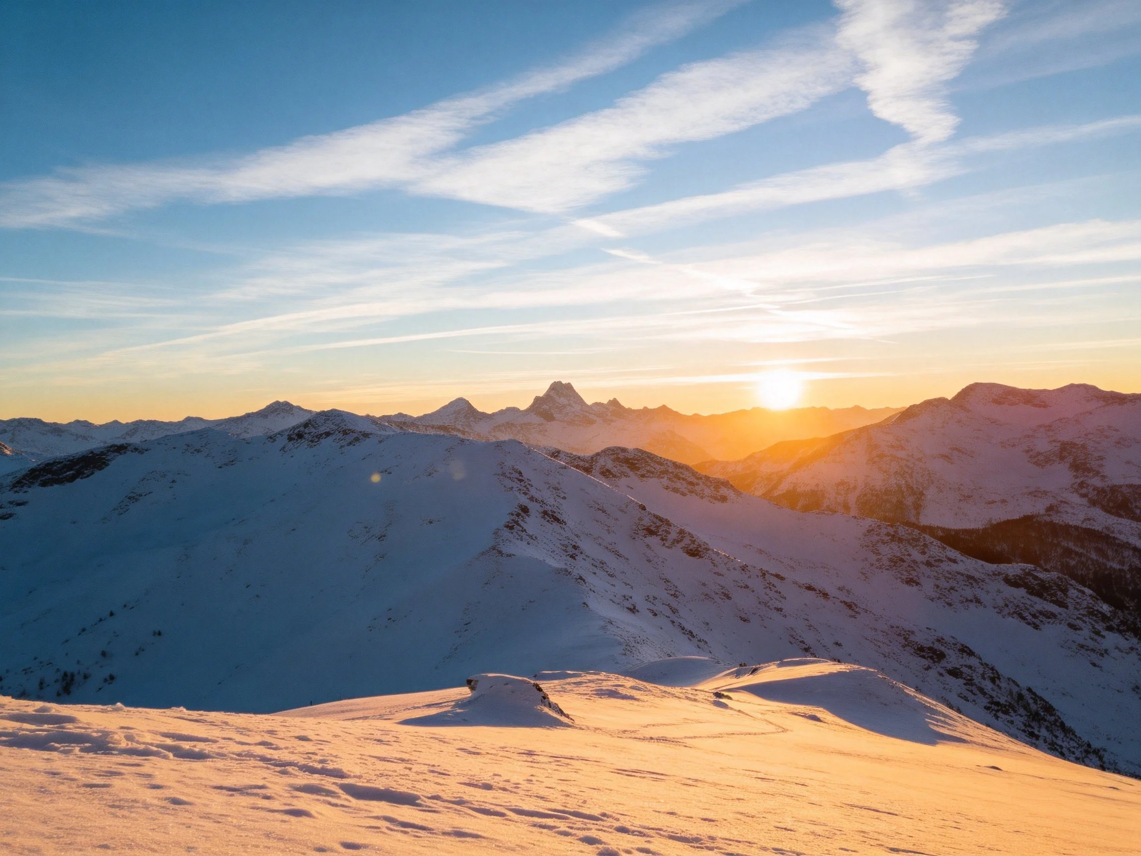 Snow-capped mountain peaks glowing at sunrise