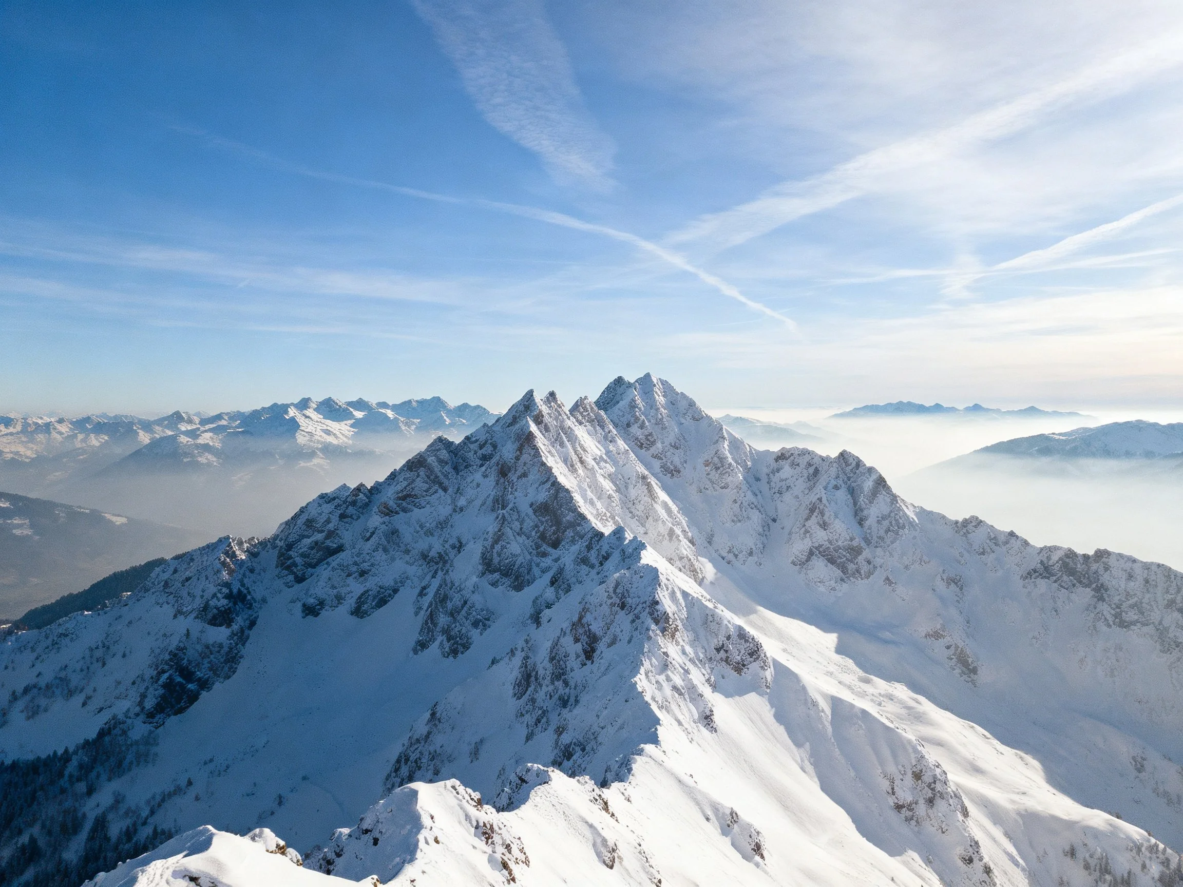 Snow - capped mountain peaks under a clear blue sky