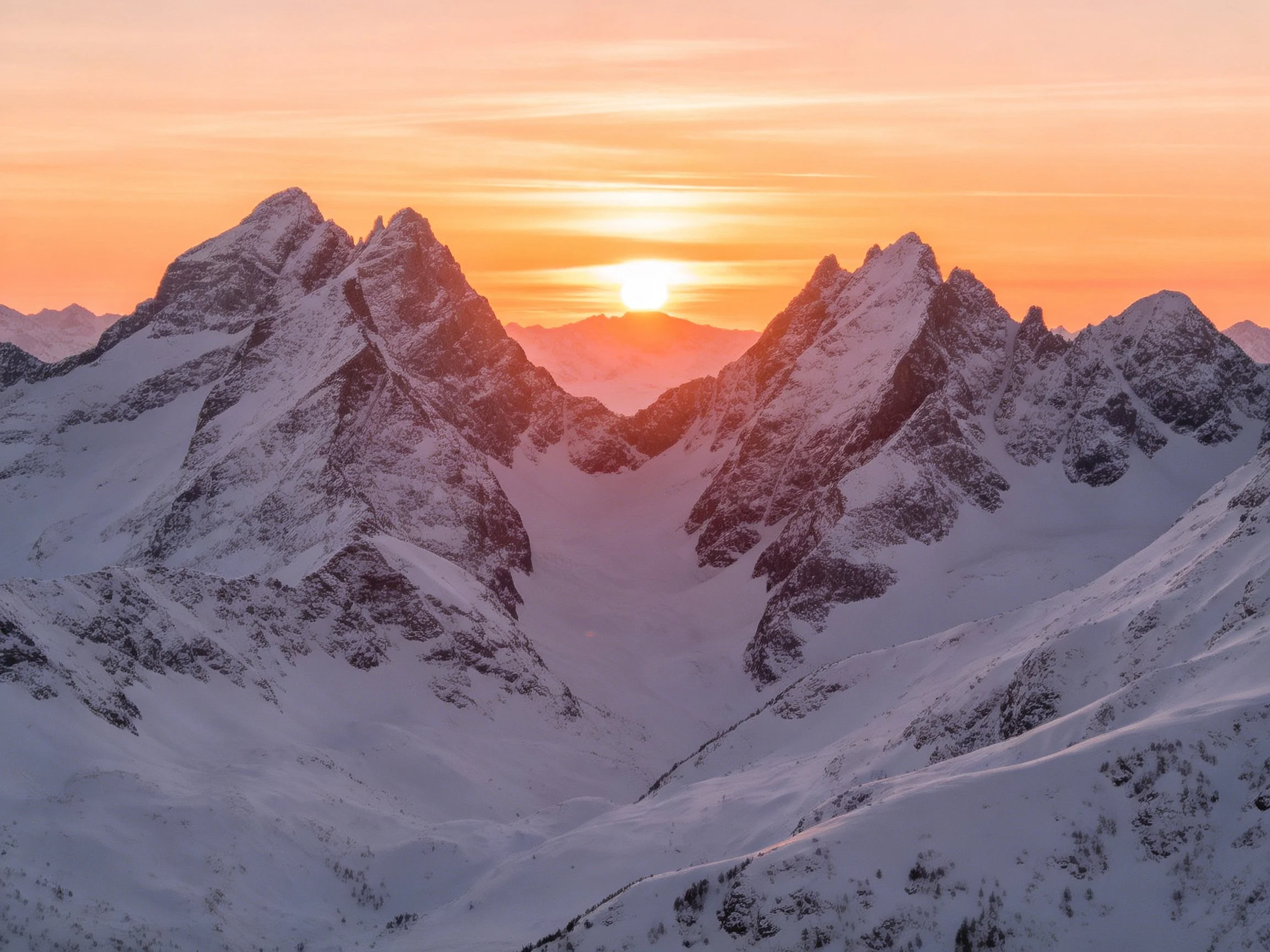 Snow - capped mountain peaks under vibrant sunset hues