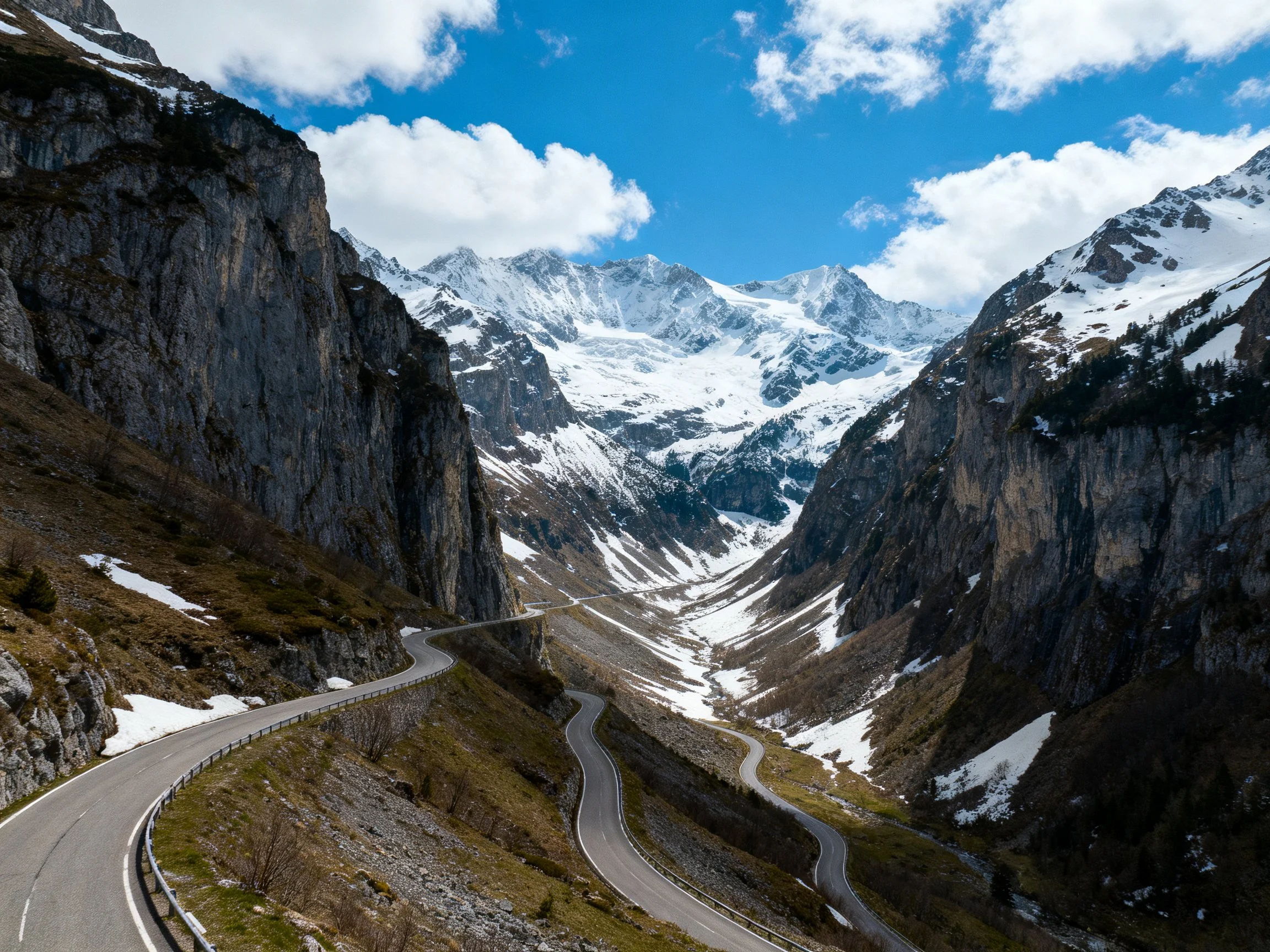 Snow-capped mountain peaks with a winding mountain road