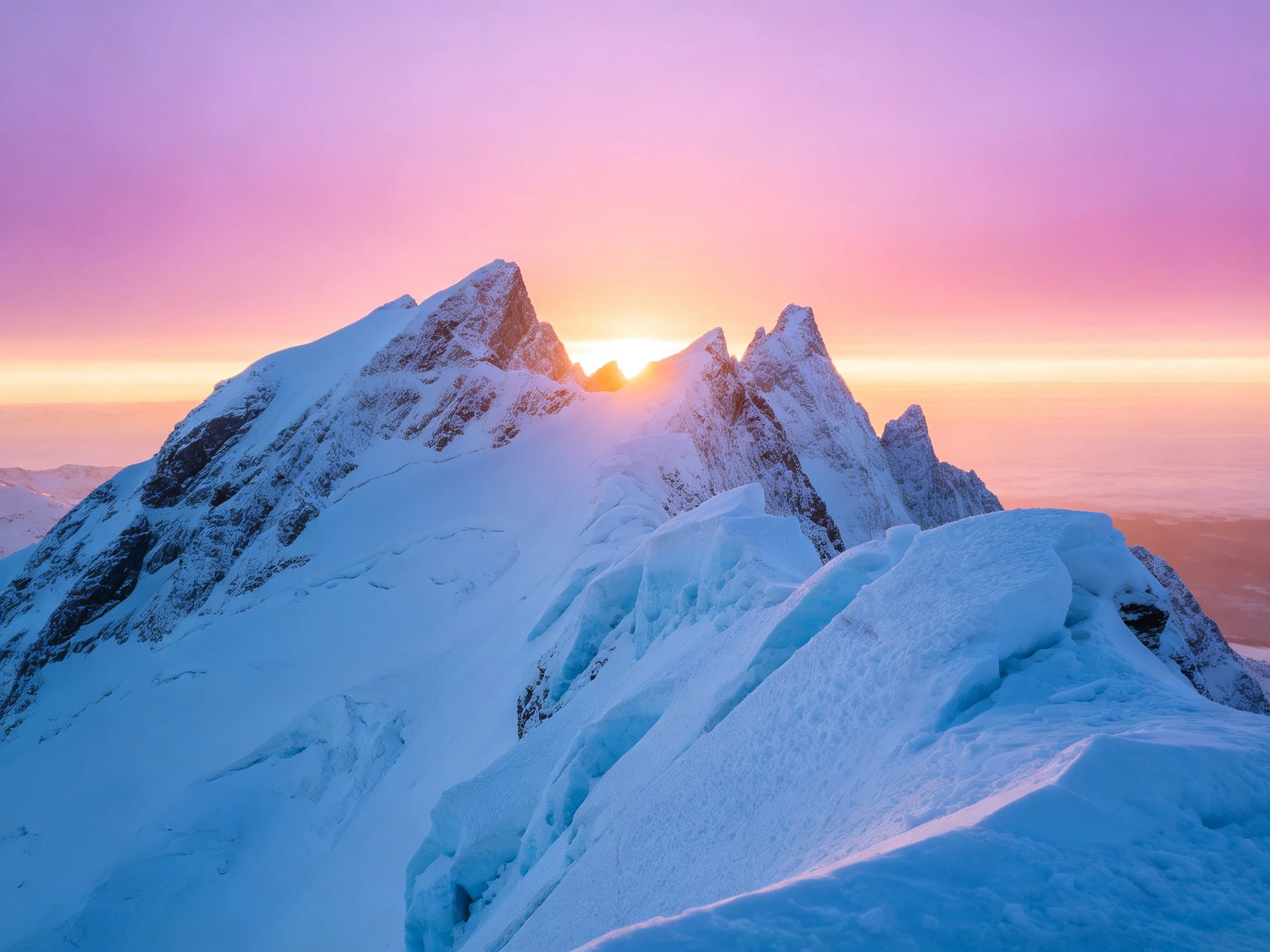 Snow-capped mountain peaks with vibrant purple-pink sunrise glow