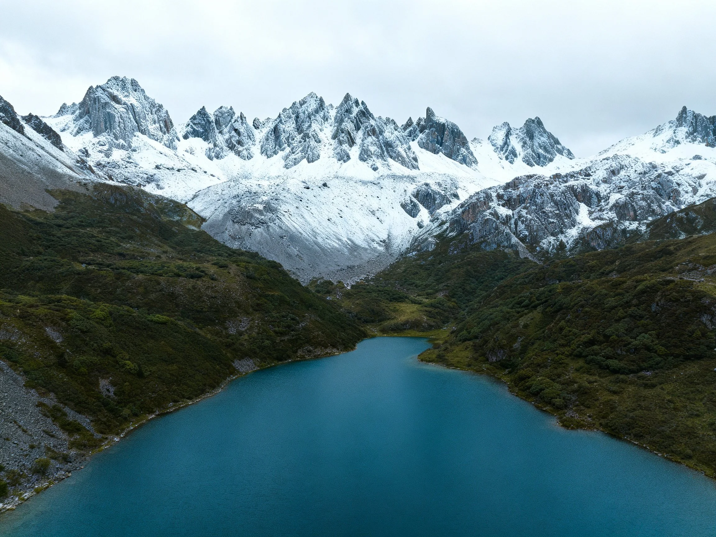 Snow-capped mountains frame a turquoise alpine lake