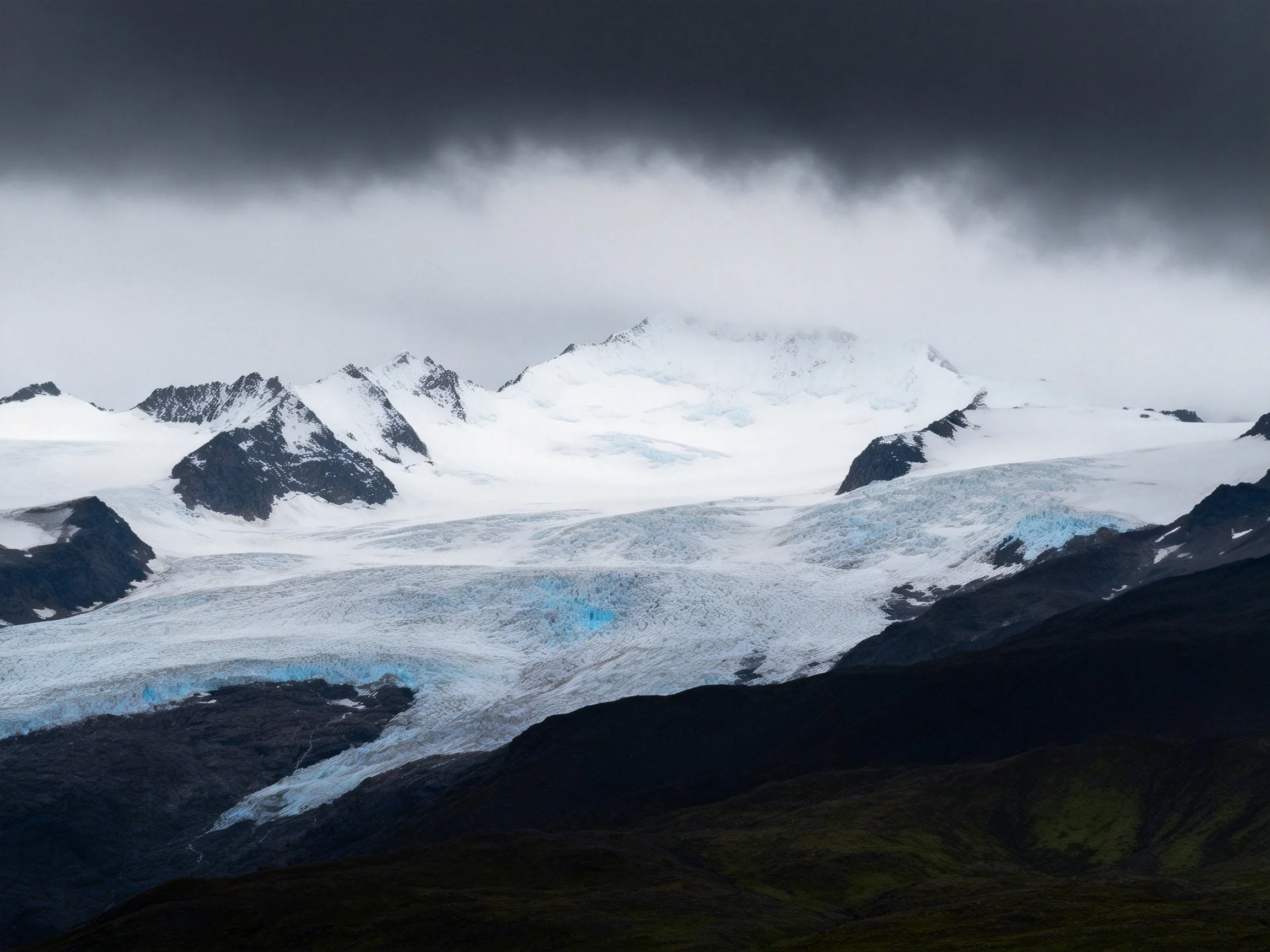 Snow-capped peaks, icy glaciers, and stormy dark skies