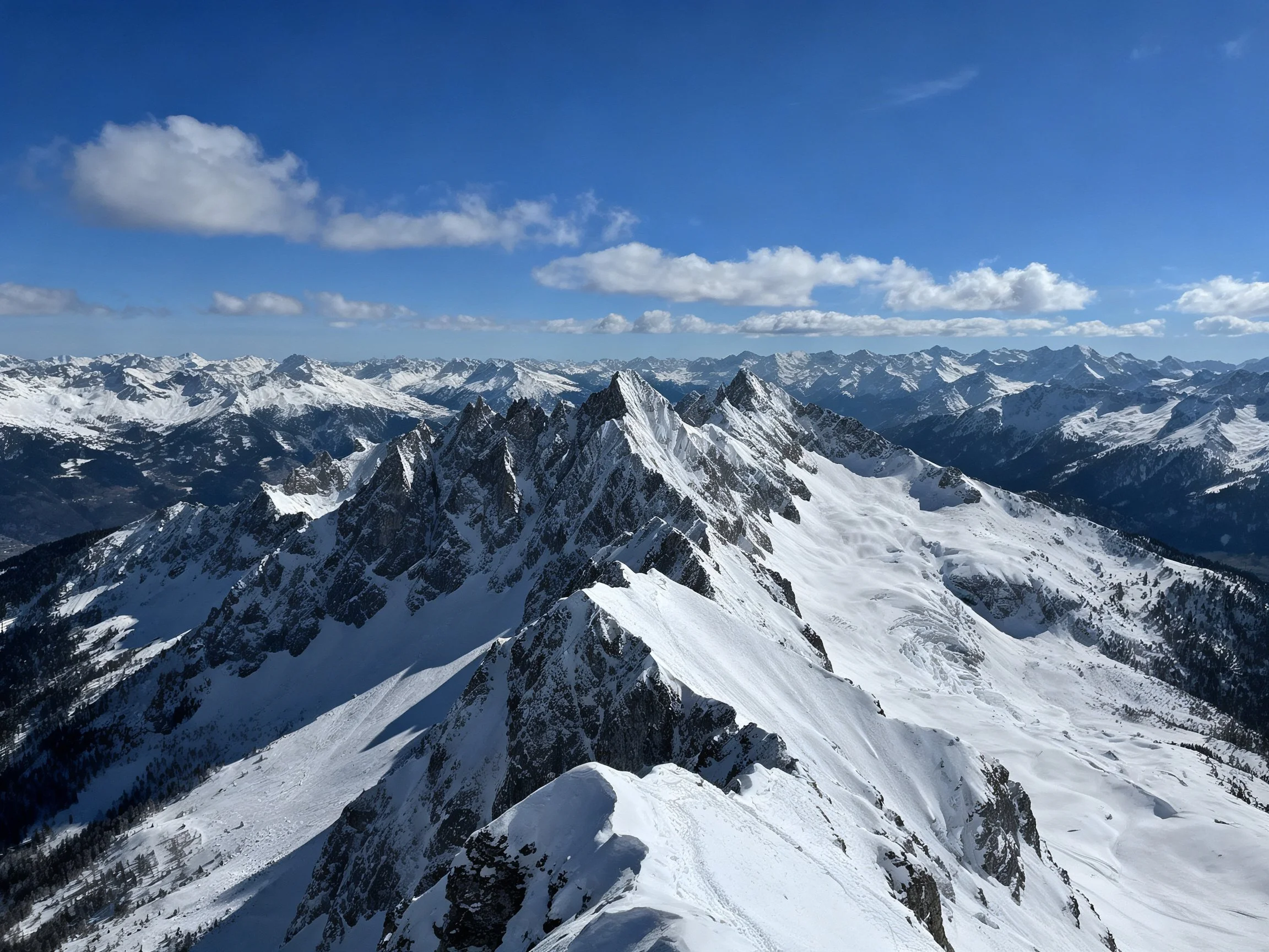 Snow-covered mountain peaks stretching into clear blue sky