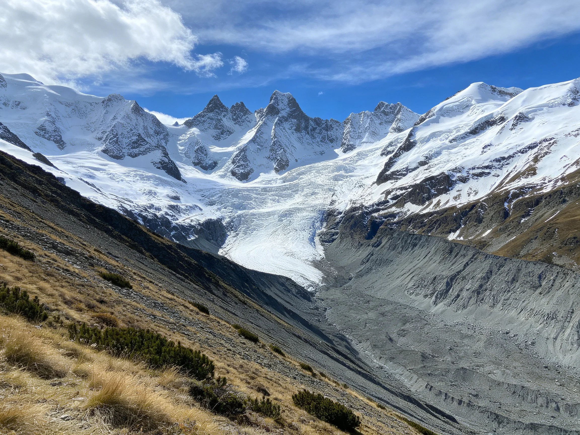 Snow-covered peaks rise above a vast glacial valley