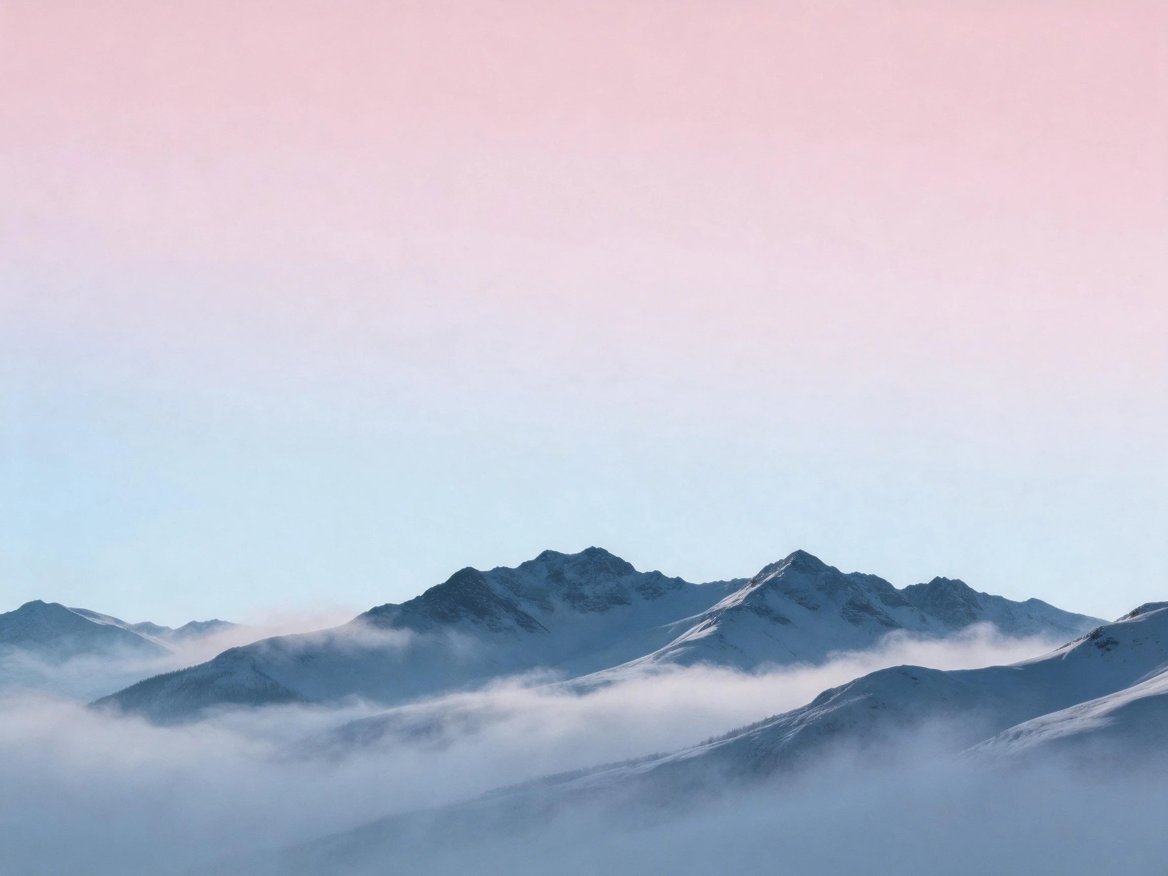 Snow-draped mountain peaks with misty clouds under pastel sky