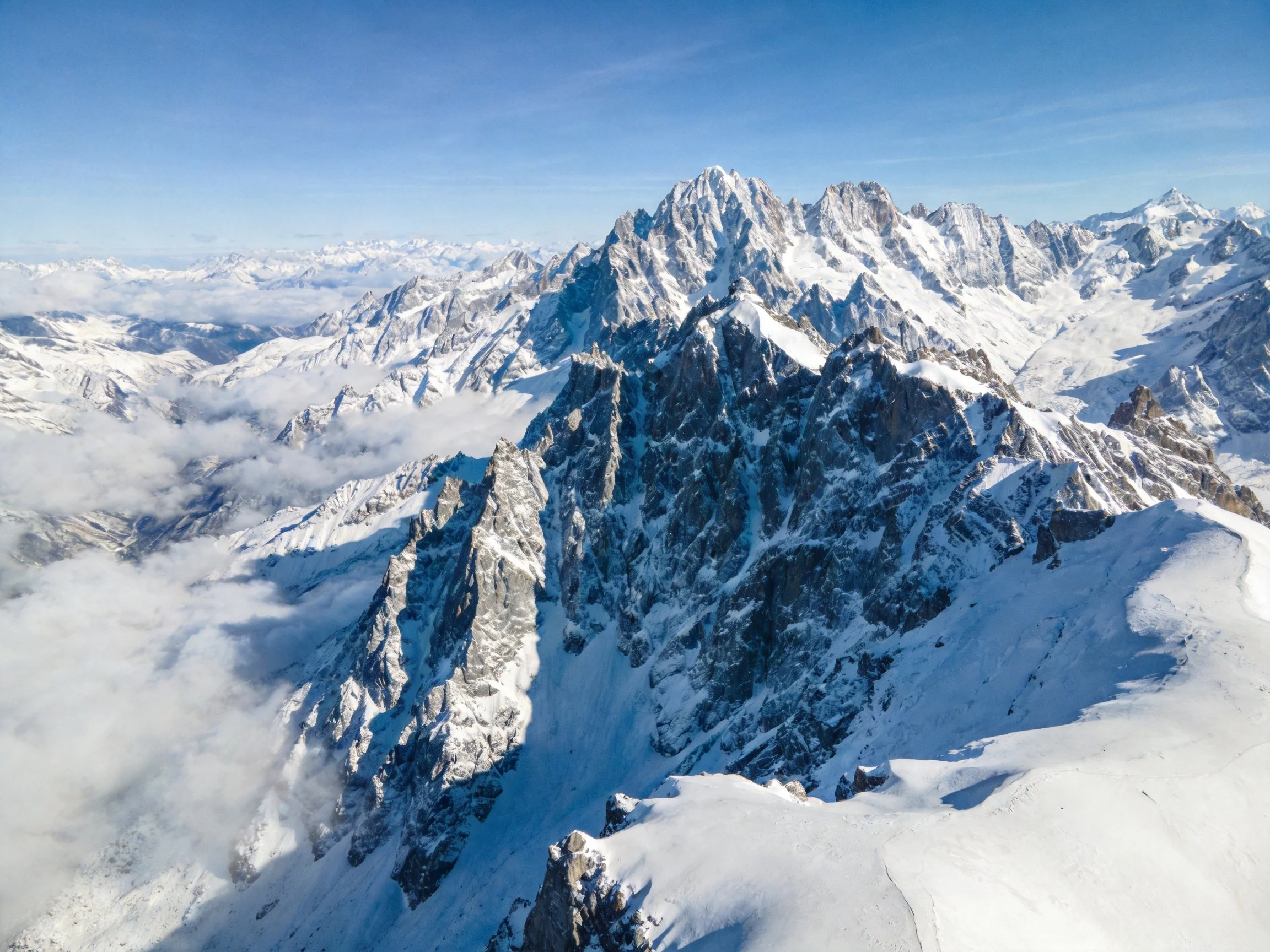 Snow-draped mountain ranges with clear blue skies