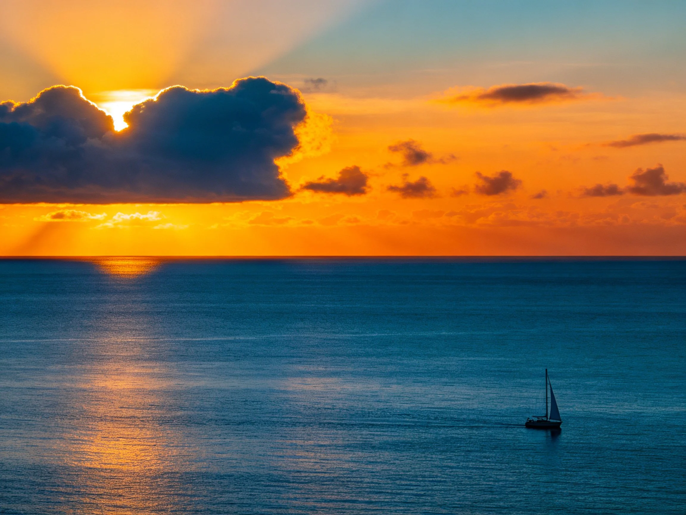 Sunset Over Calm Ocean With Sailboat