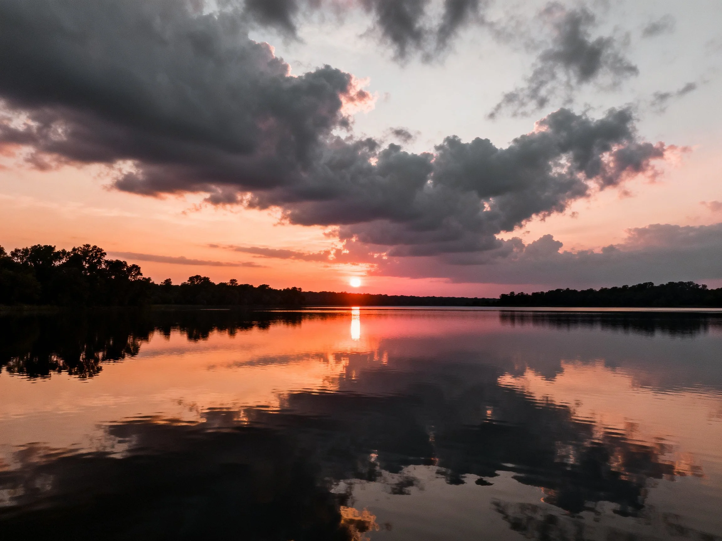 Sunset Over Calm Waters With Dramatic Clouds