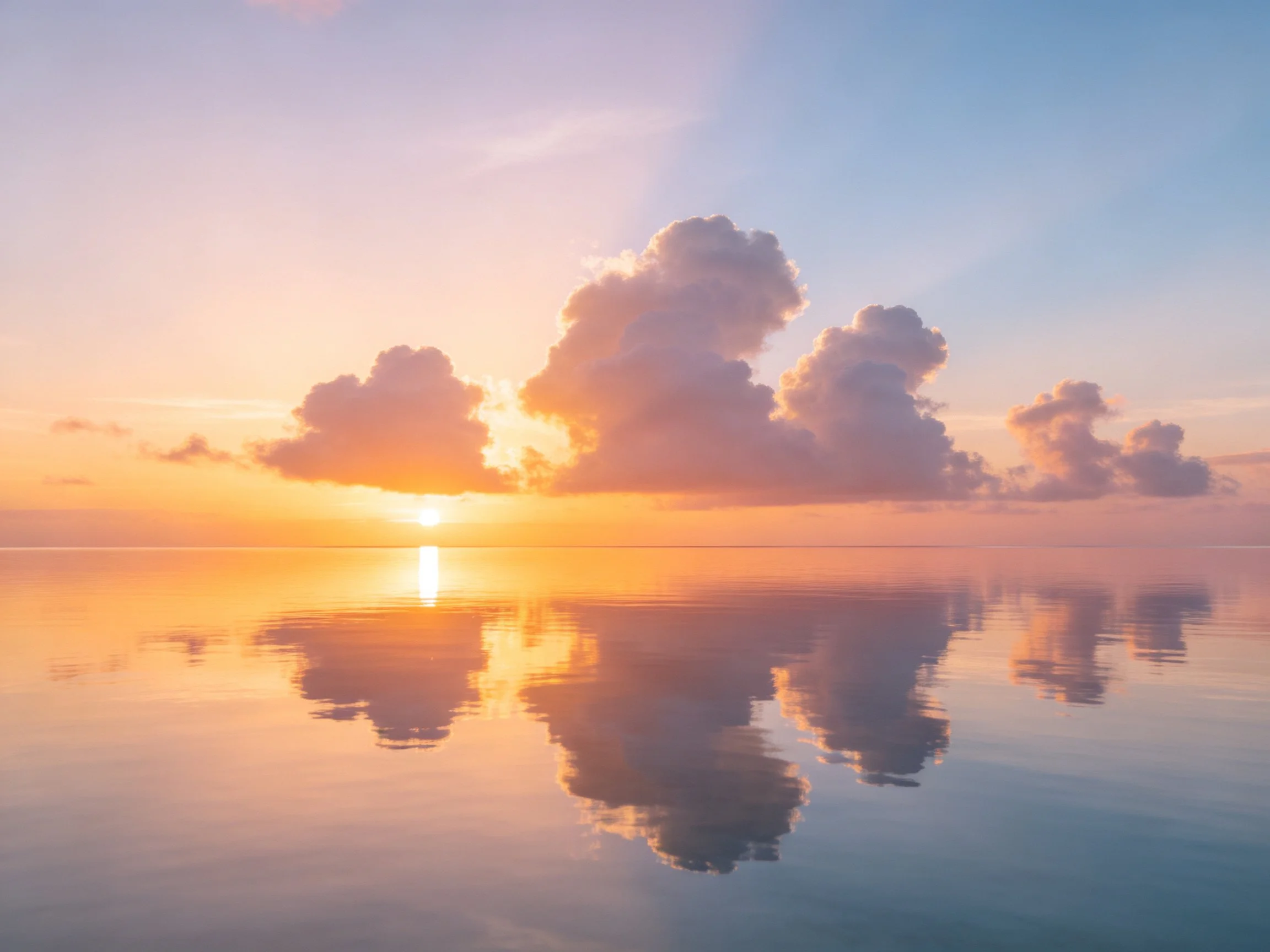 Sunset with fluffy cloud reflections on calm water