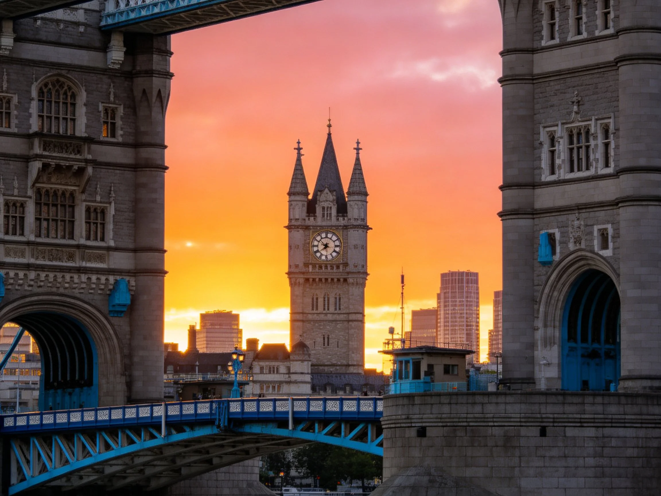 Tower Bridge frames clock tower at vibrant sunset