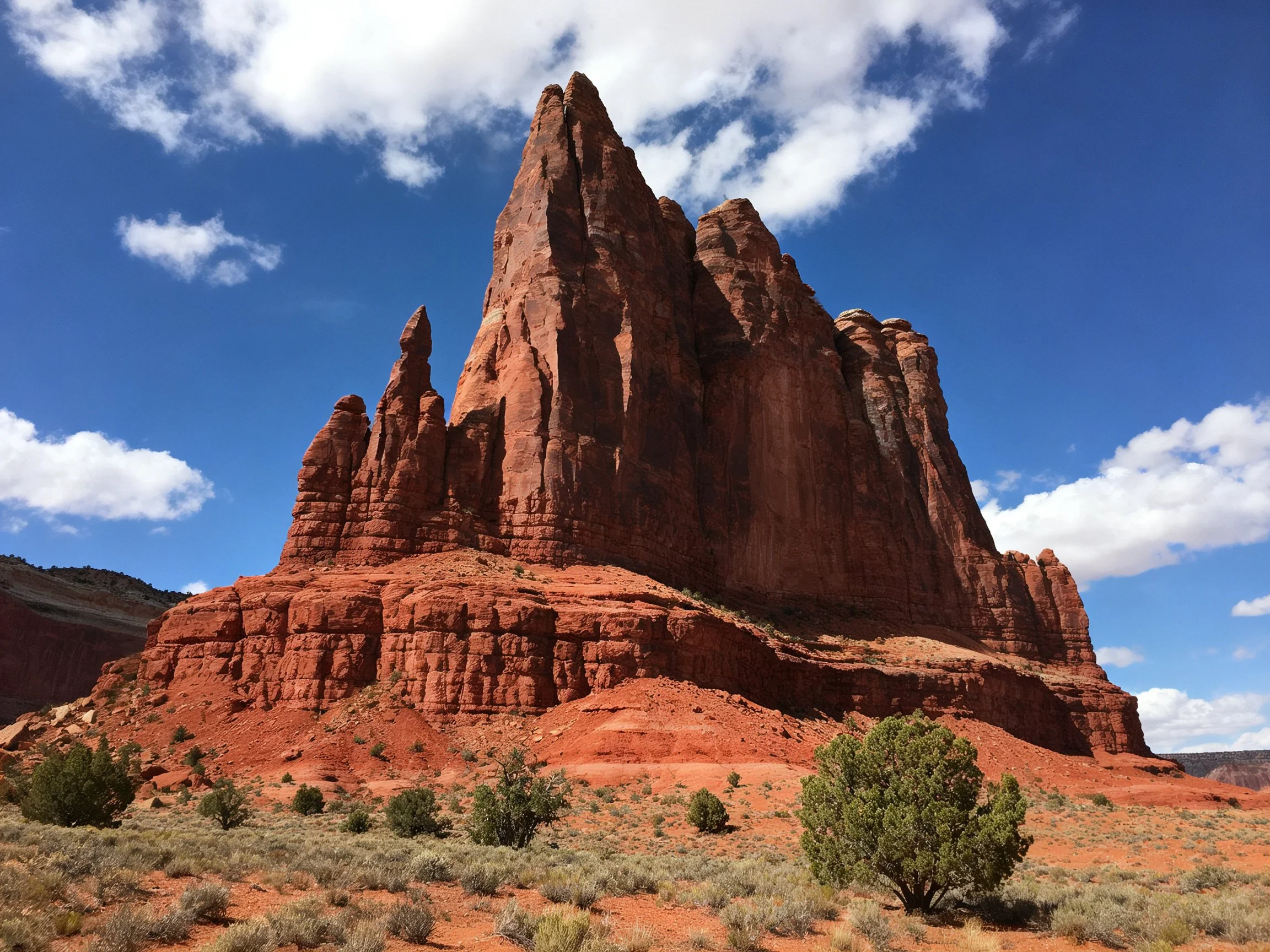 Towering red sandstone formation under bright blue sky