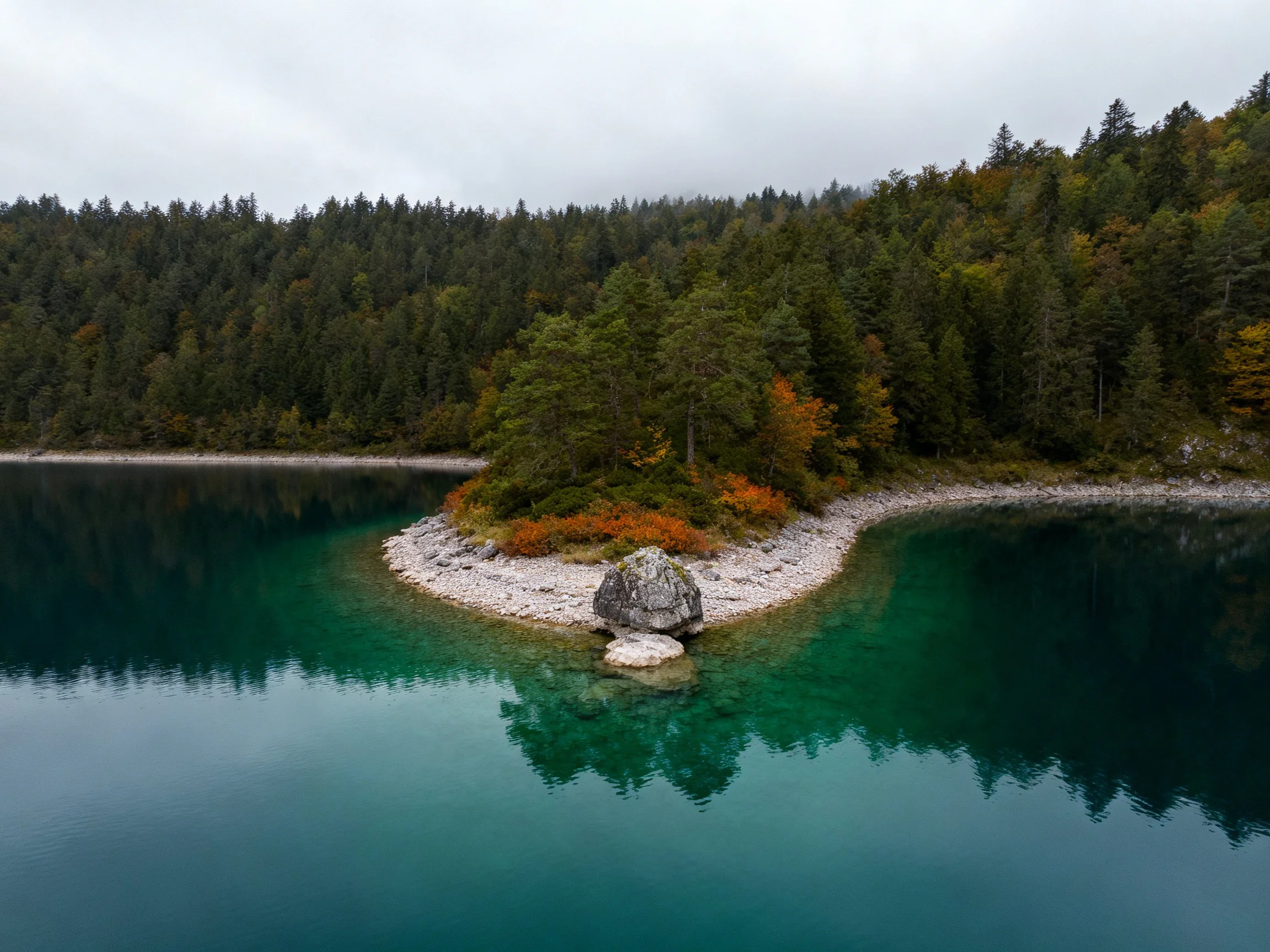 Turquoise Lake with Forested Island and Rocky Shore