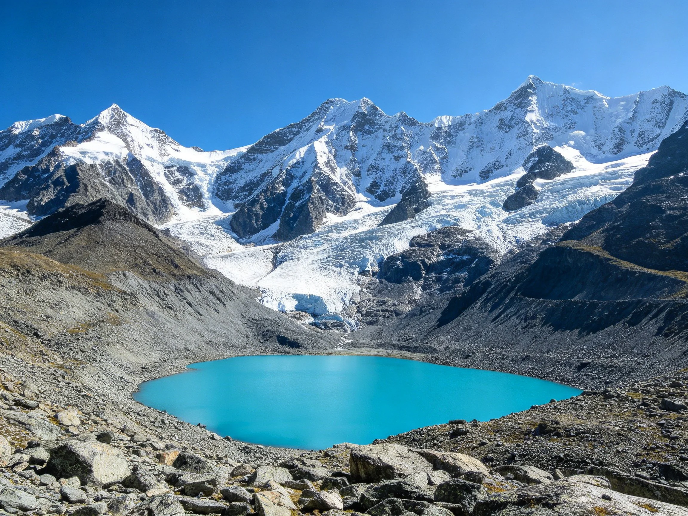 Turquoise glacial lake surrounded by rugged rocky slopes and snow - covered peaks