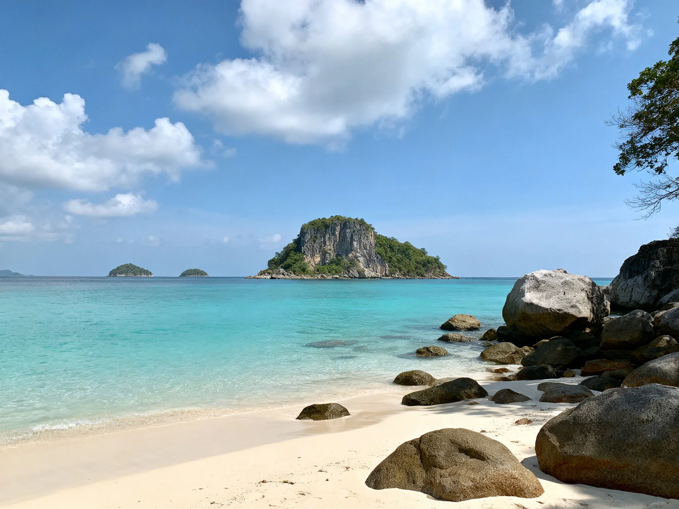 Turquoise waters, white sand, rocky shores, distant green islands