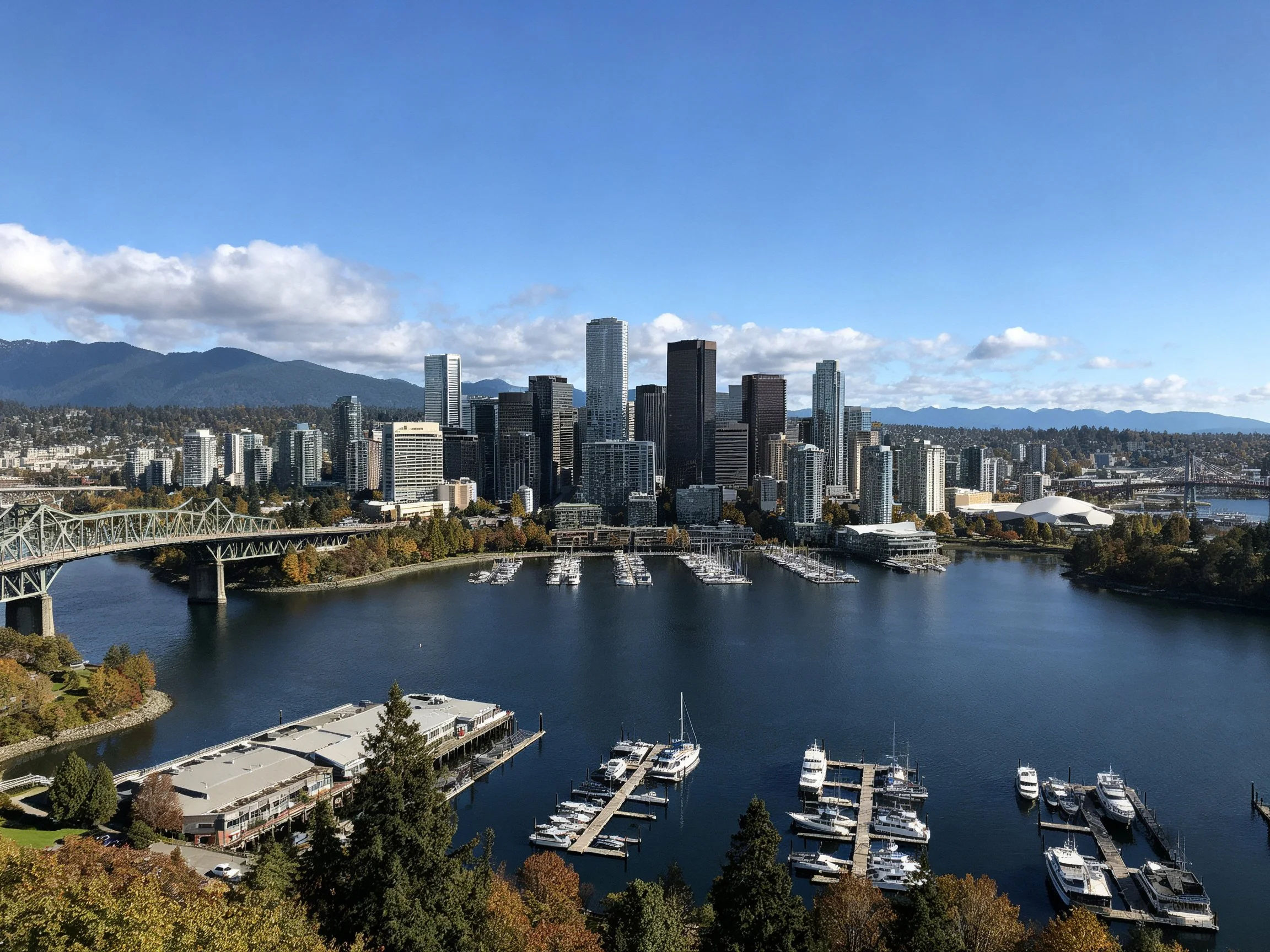 Urban skyline with marina, bridge, and mountain backdrop