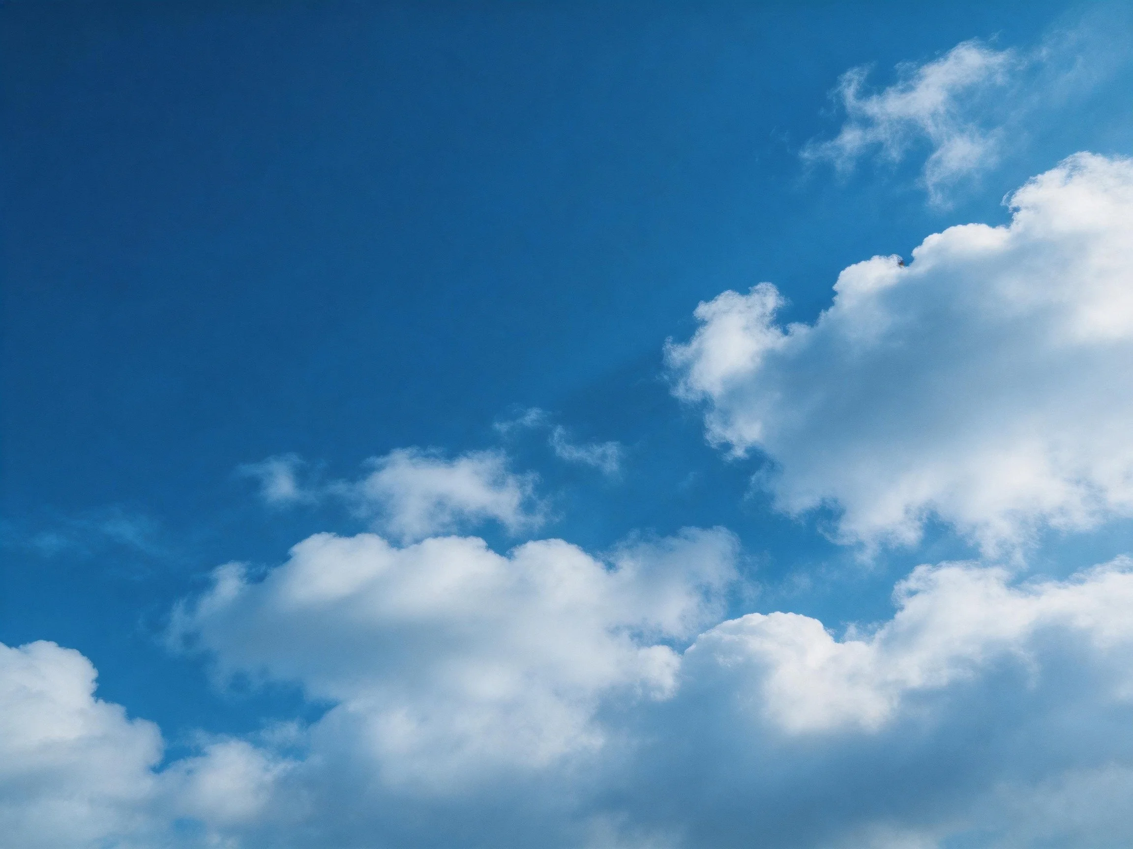 Vibrant blue sky with fluffy white cumulus clouds