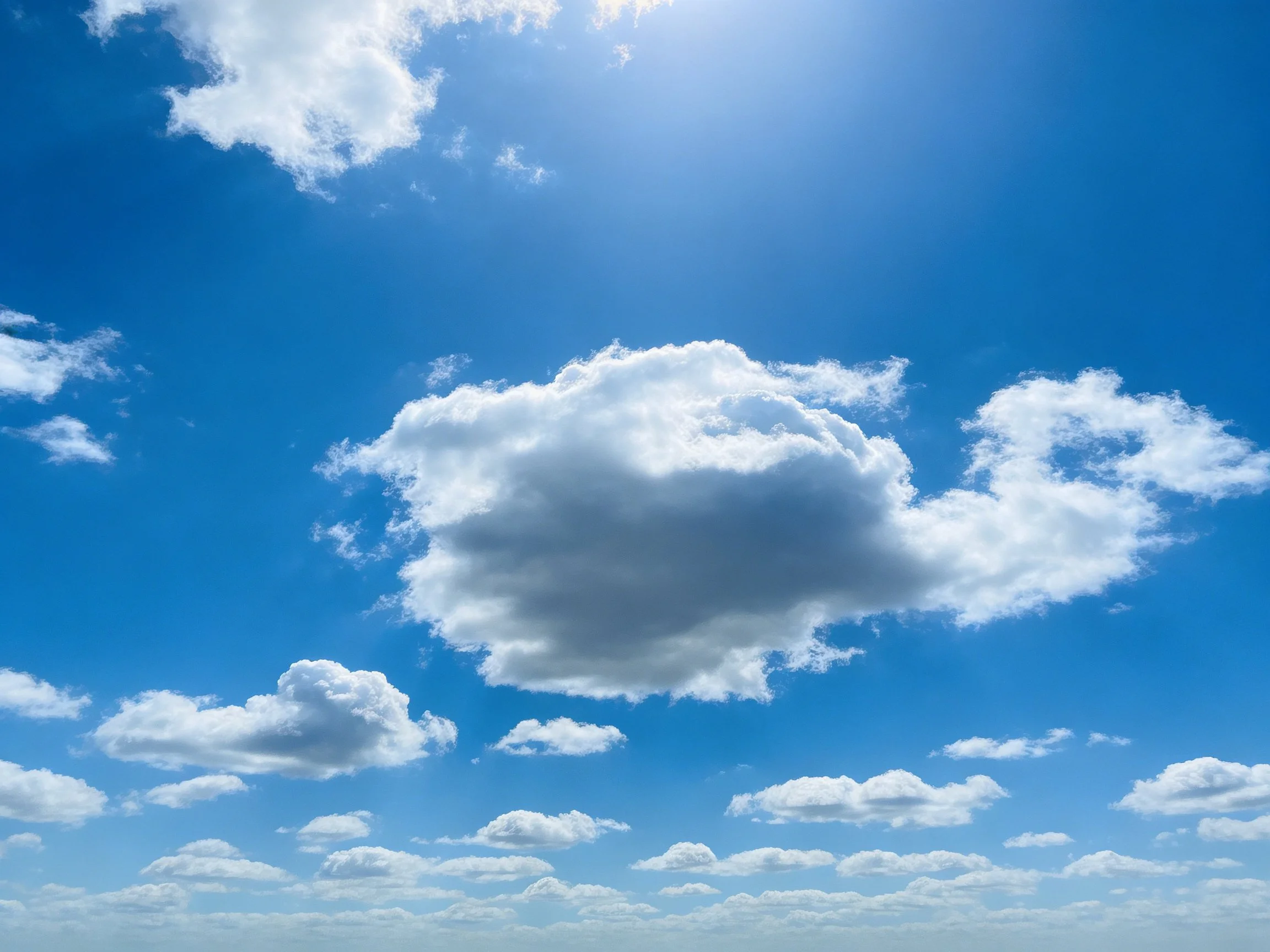 Vibrant blue sky with scattered white and dark clouds