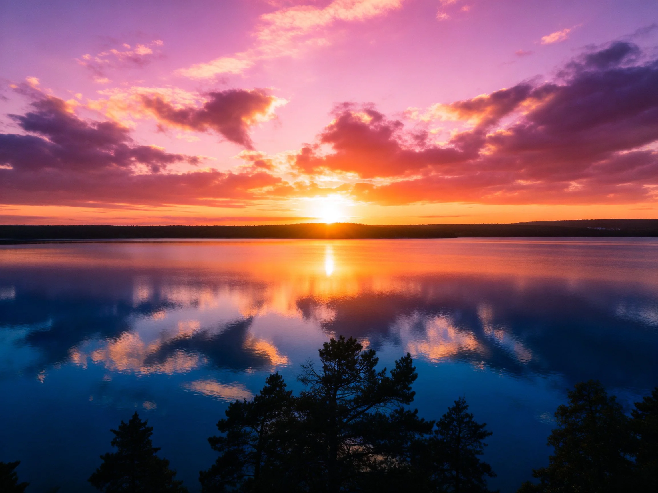 Vibrant sunset over calm lake with colorful sky reflections