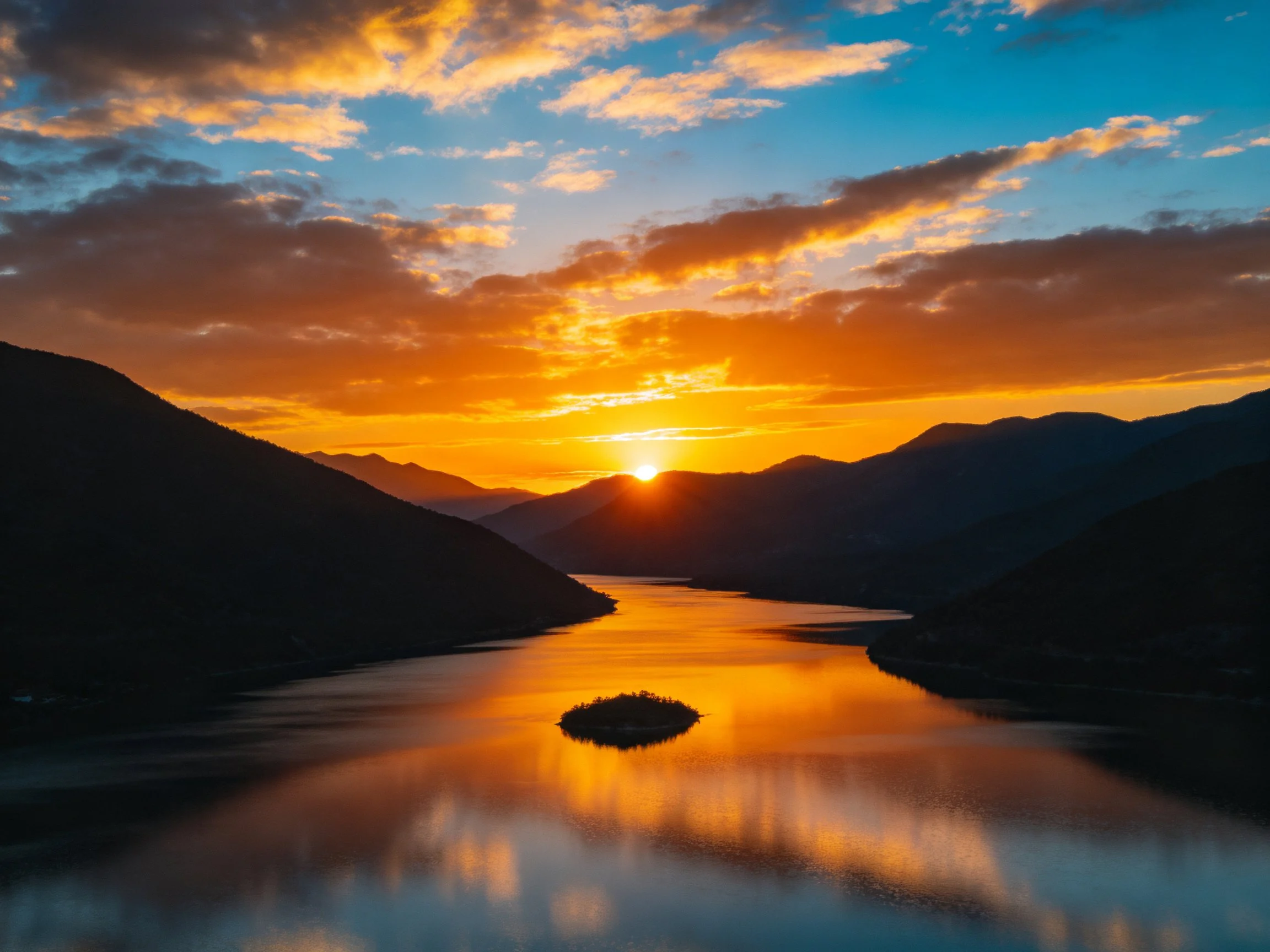 Vibrant sunset over mountain lake with golden reflections
