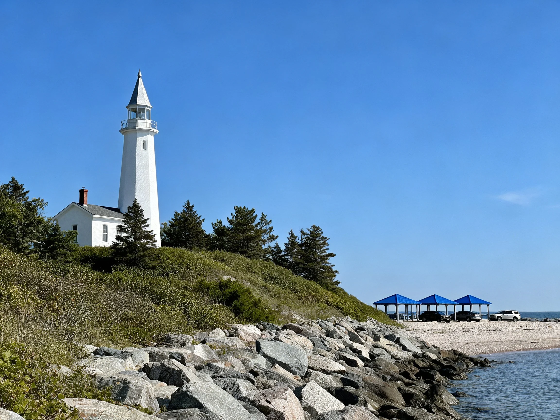 White Lighthouse by Rocky Beach with Blue Shelters