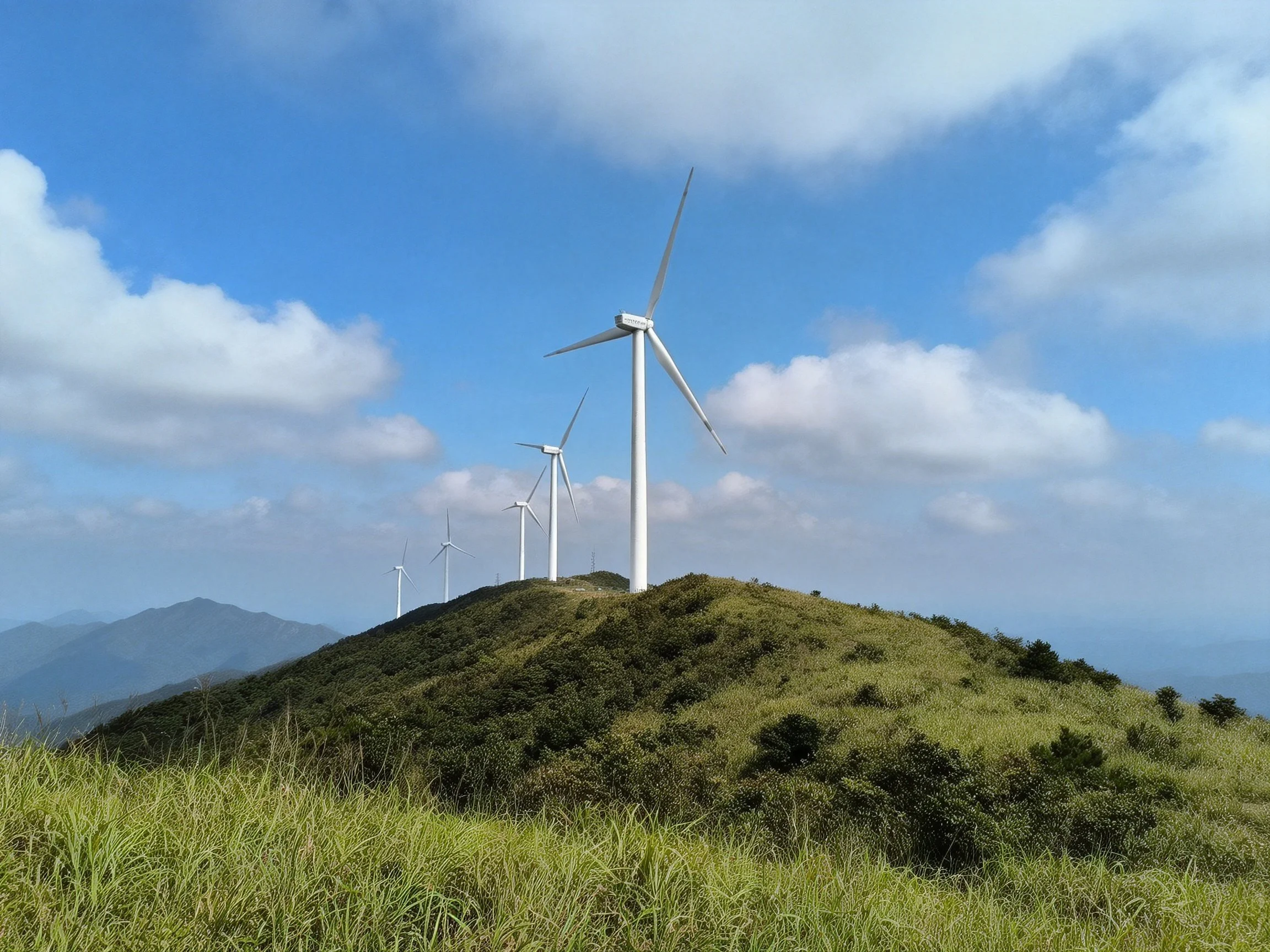 Wind turbines atop a lush green hill with blue sky